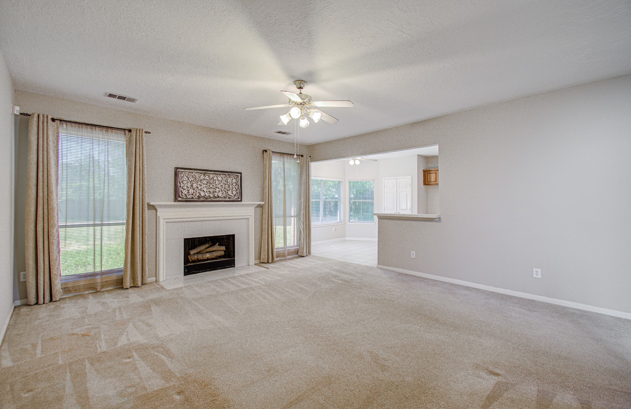 Spacious family room features a fireplace, backyard-facing windows and an open connection to the kitchen and breakfast area.