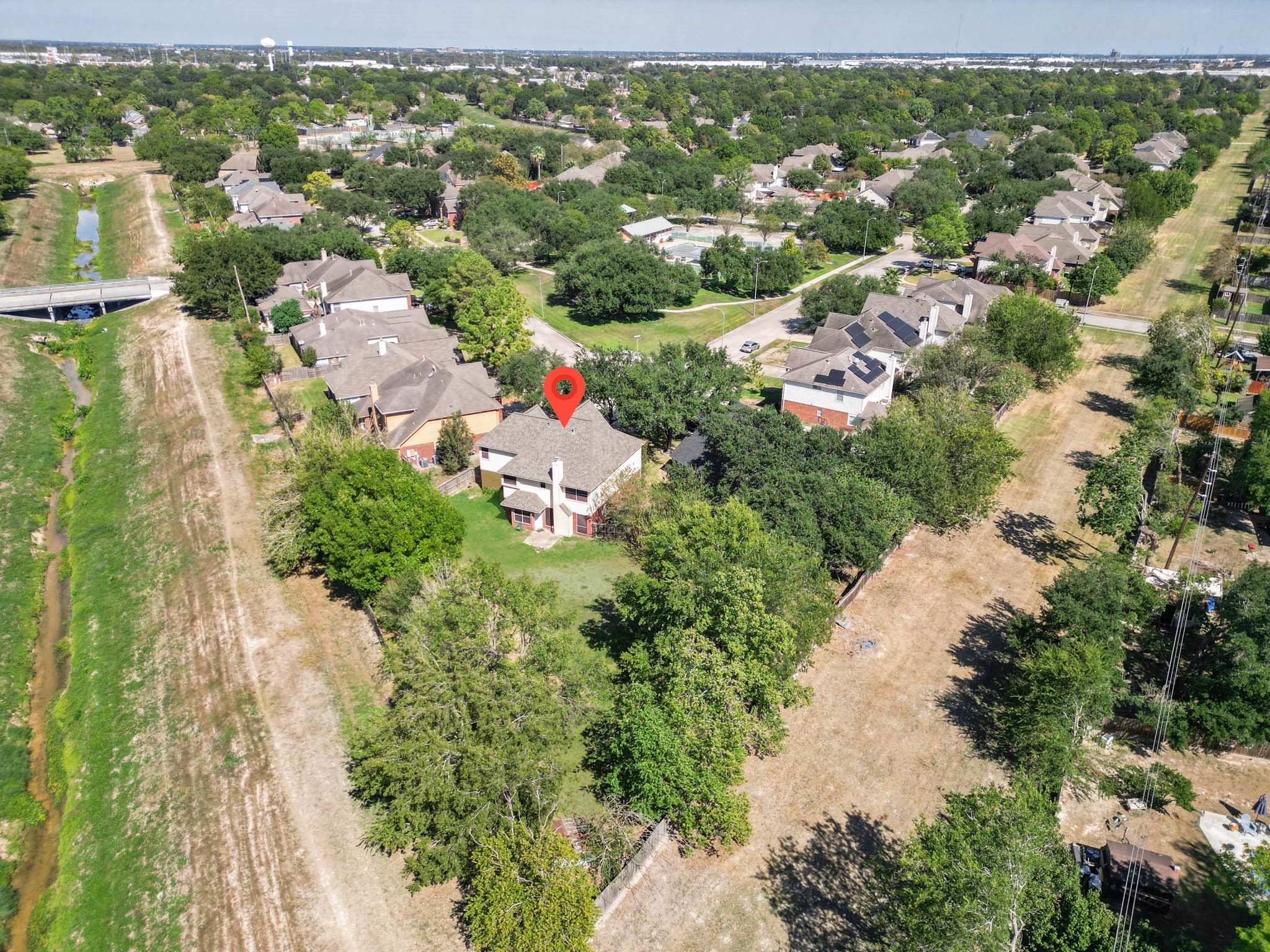 An elevated look at the surrounding neighborhood showcases the established community, mature trees and spacious residential setting.