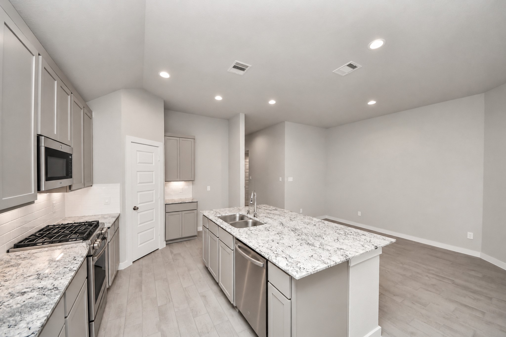 Modern kitchen featuring sleek granite countertops, stainless steel appliances, and ample cabinetry, seamlessly flowing into a spacious open-concept living area. Modern kitchen featuring sleek granite countertops, stainless steel appliances, and ample cabinetry, seamlessly flowing into a spacious open-concept living area.