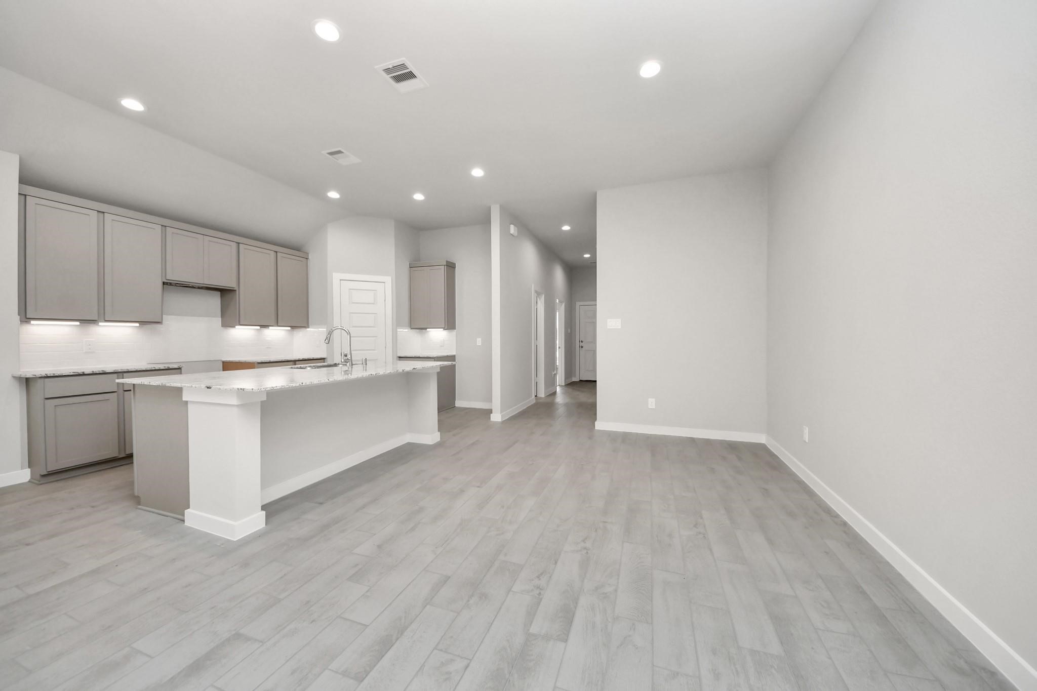Bright and spacious open-concept kitchen and living area featuring modern cabinetry, sleek countertops, and elegant flooring. Bright and spacious open-concept kitchen and living area featuring modern cabinetry, sleek countertops, and elegant flooring.