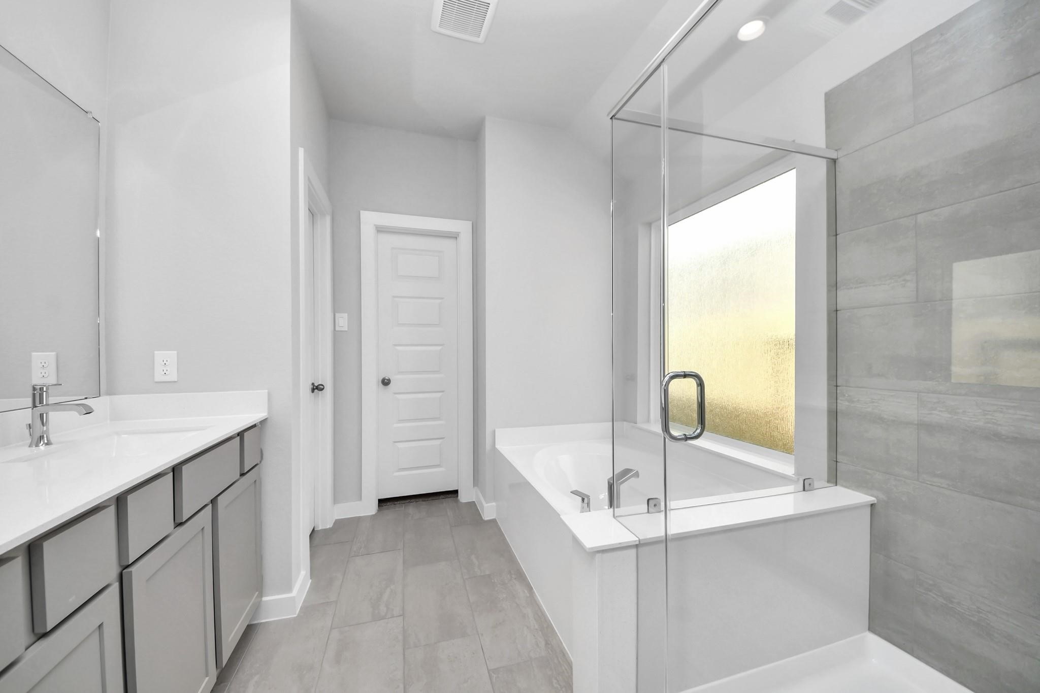 Bright and modern bathroom featuring a spacious glass-enclosed shower, sleek dual vanities, and elegant tile flooring for a luxurious feel.