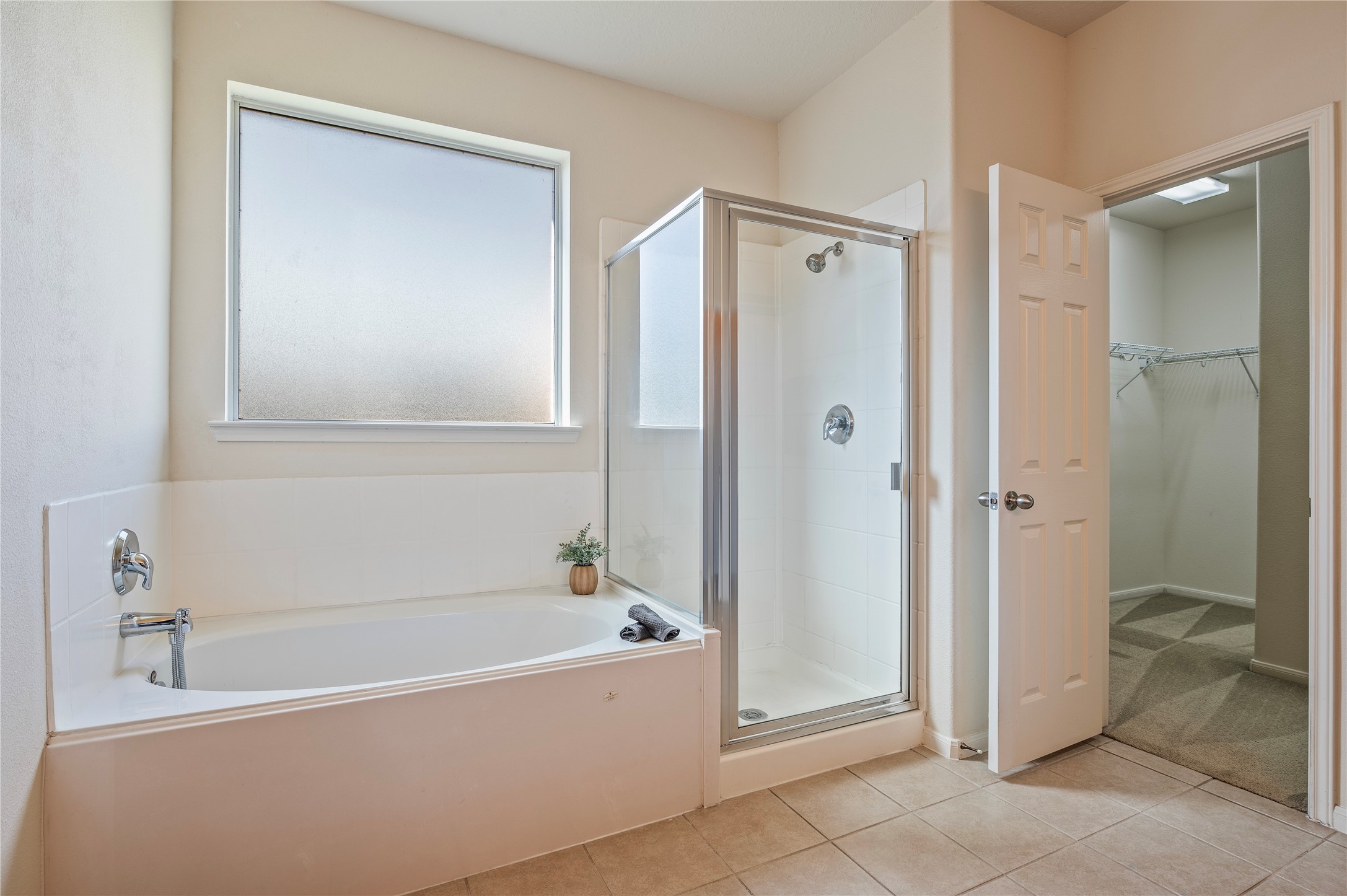 Unwind in the primary bath with a soaking garden tub and separate glass-enclosed shower.