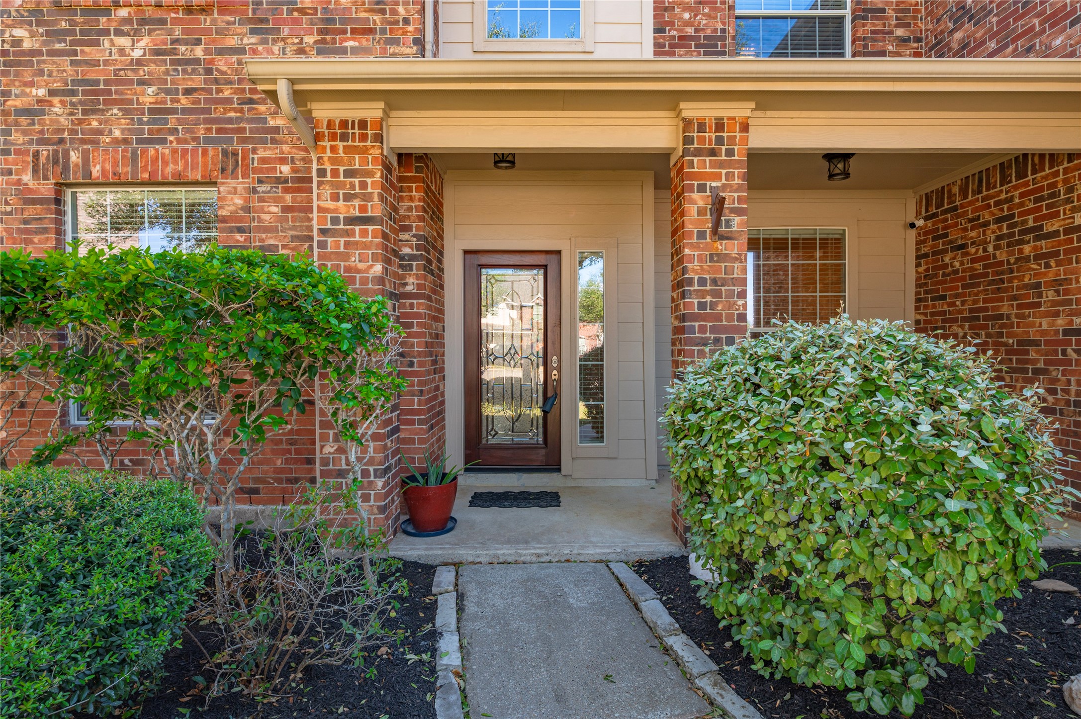 A welcoming front walkway leads to the wood front door with decorative glass panels. A welcoming front walkway leads to the wood front door with decorative glass panels.