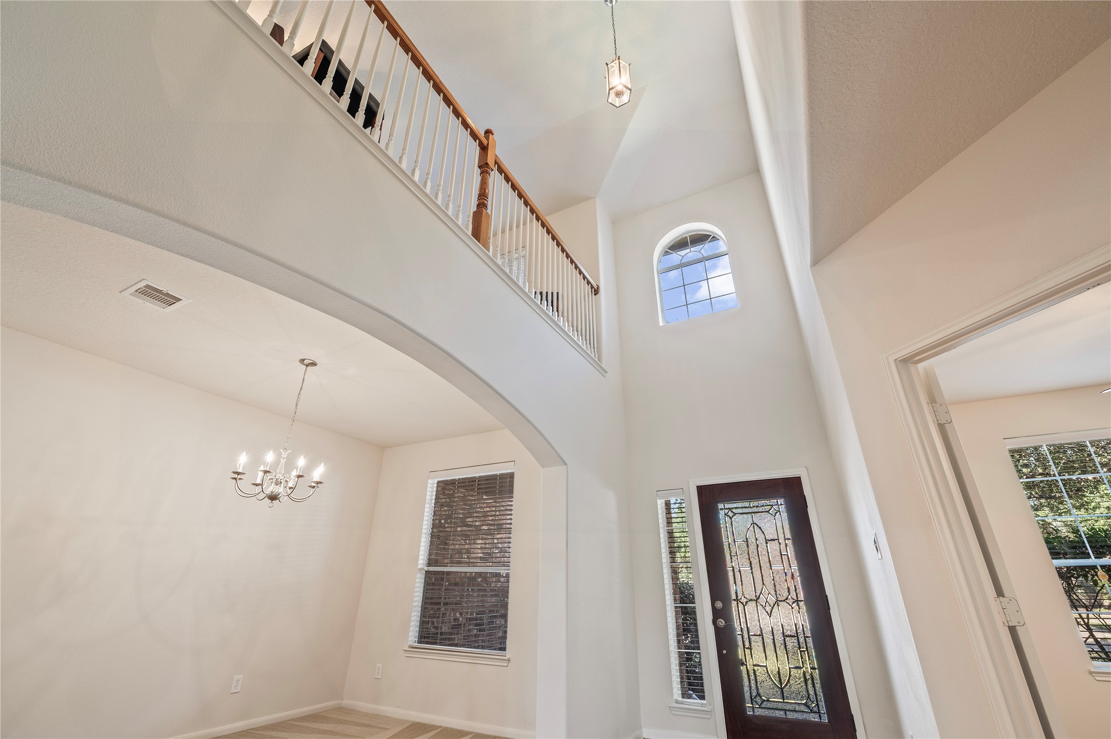 The open upstairs walkway overlooks the grand entry, highlighting the home's high ceilings and natural light. The open upstairs walkway overlooks the grand entry, highlighting the home's high ceilings and natural light.