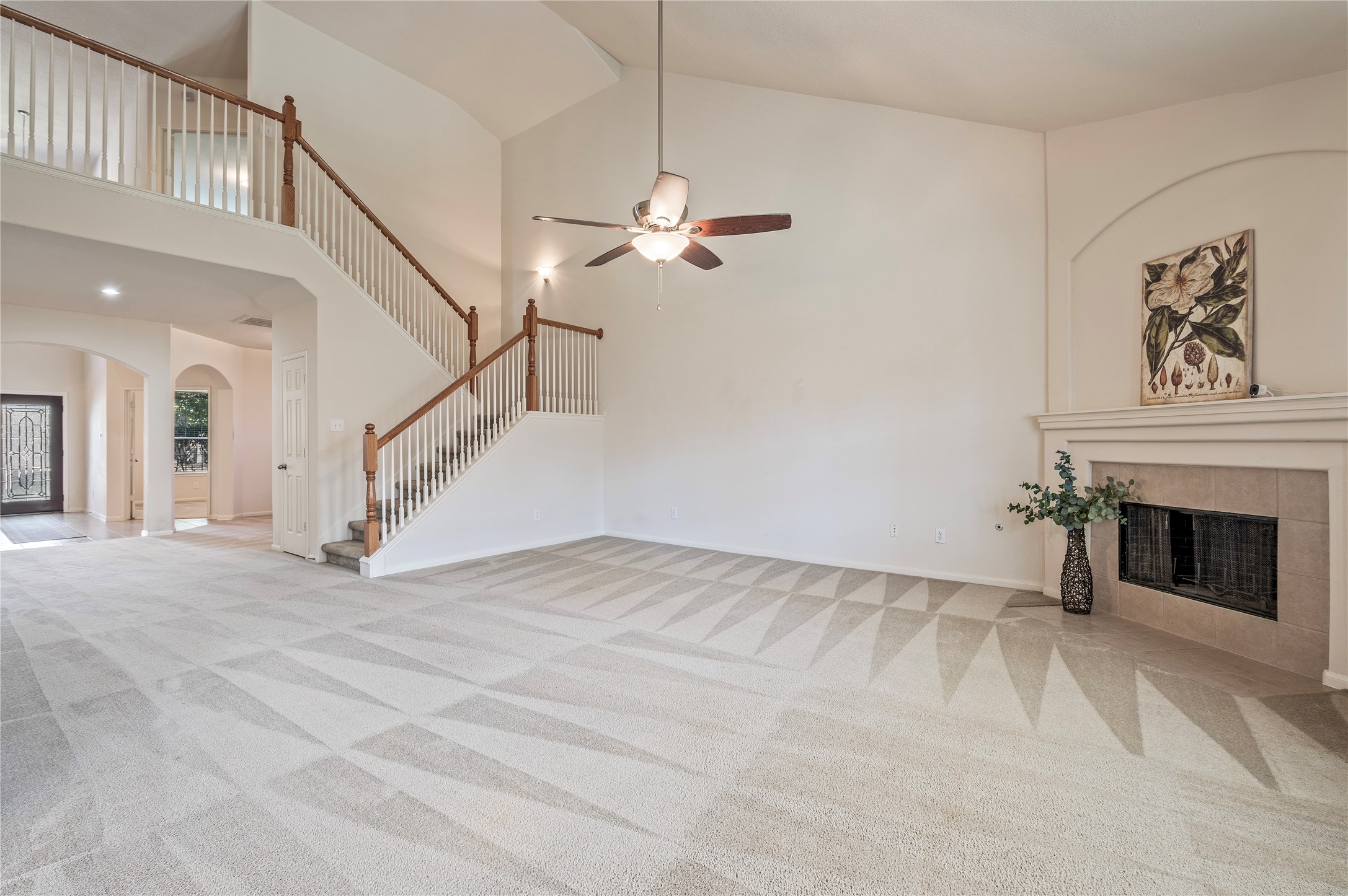 A stone fireplace with gas logs anchors the family room, with the staircase rising to the second floor.