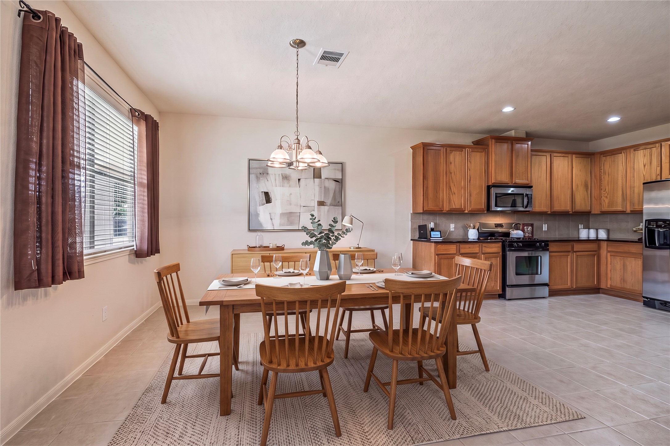 The spacious breakfast area with tile floors opens to the kitchen, great for casual meals. Room is virtually staged.