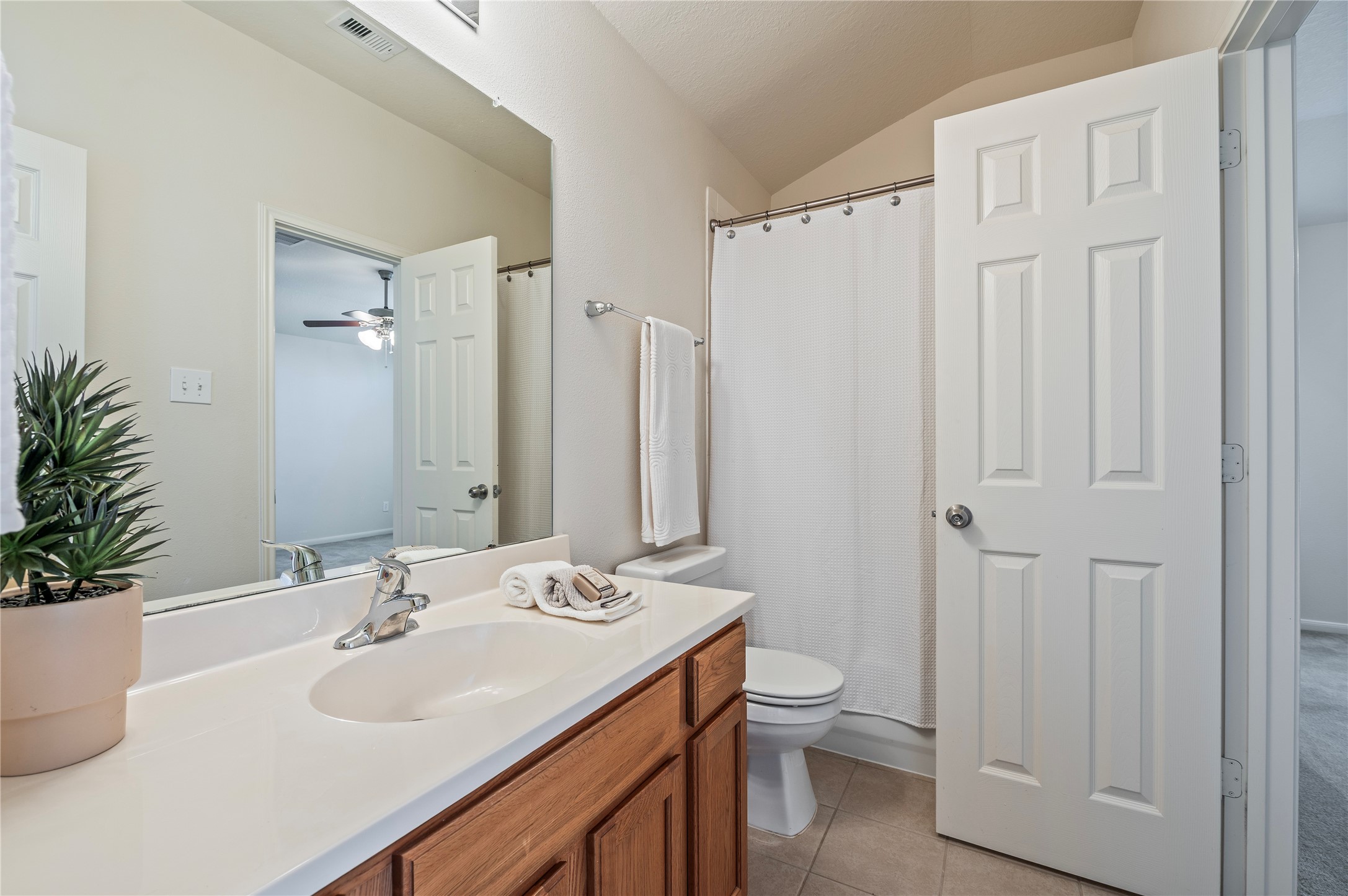 The upstairs full bath has a large vanity and a tub/shower combo, shared by two secondary bedrooms.