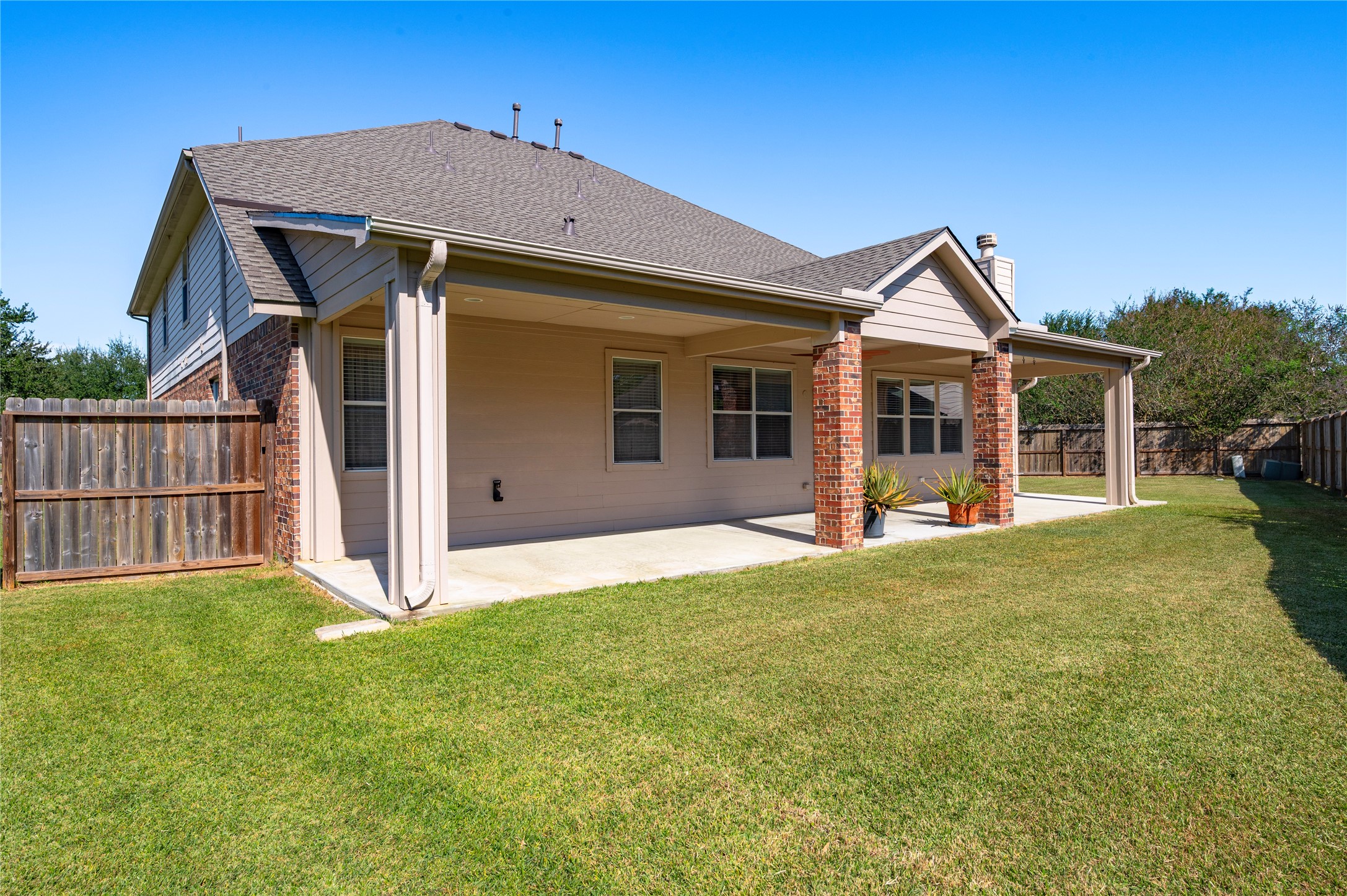 The rear of the home and covered patio, set on the oversized 0.34-acre lot.