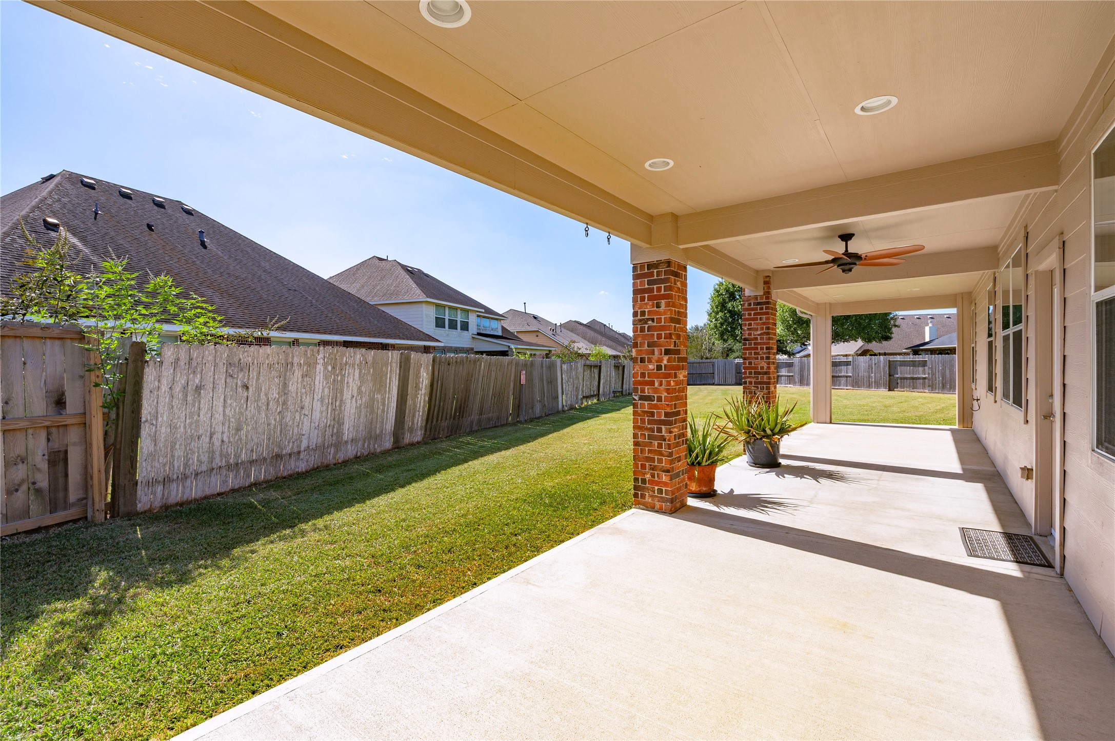 The covered patio overlooks the large backyard, an easy spot to keep an eye on outdoor activities.