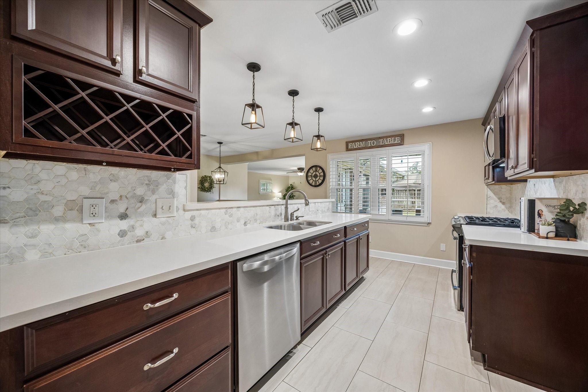 Patterned backsplash and integrated wine storage add character and function to the kitchen. Long stretches of counter space and upper and lower cabinetry keep preparation areas and everyday essentials close at hand.