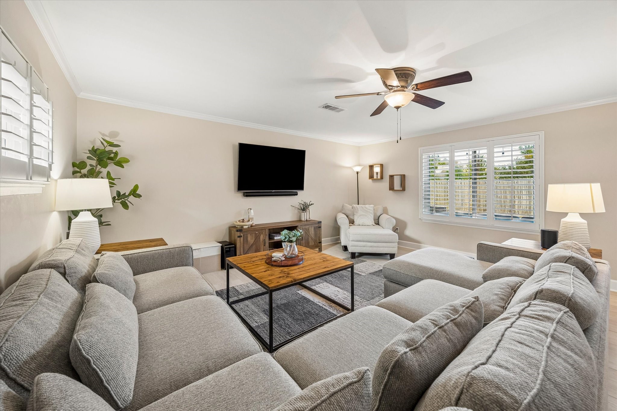Windows and a glass exterior door bring backyard views into the living room. Direct outdoor access connects the main gathering space with the rear deck, making it easy to move between indoor and outdoor activities.