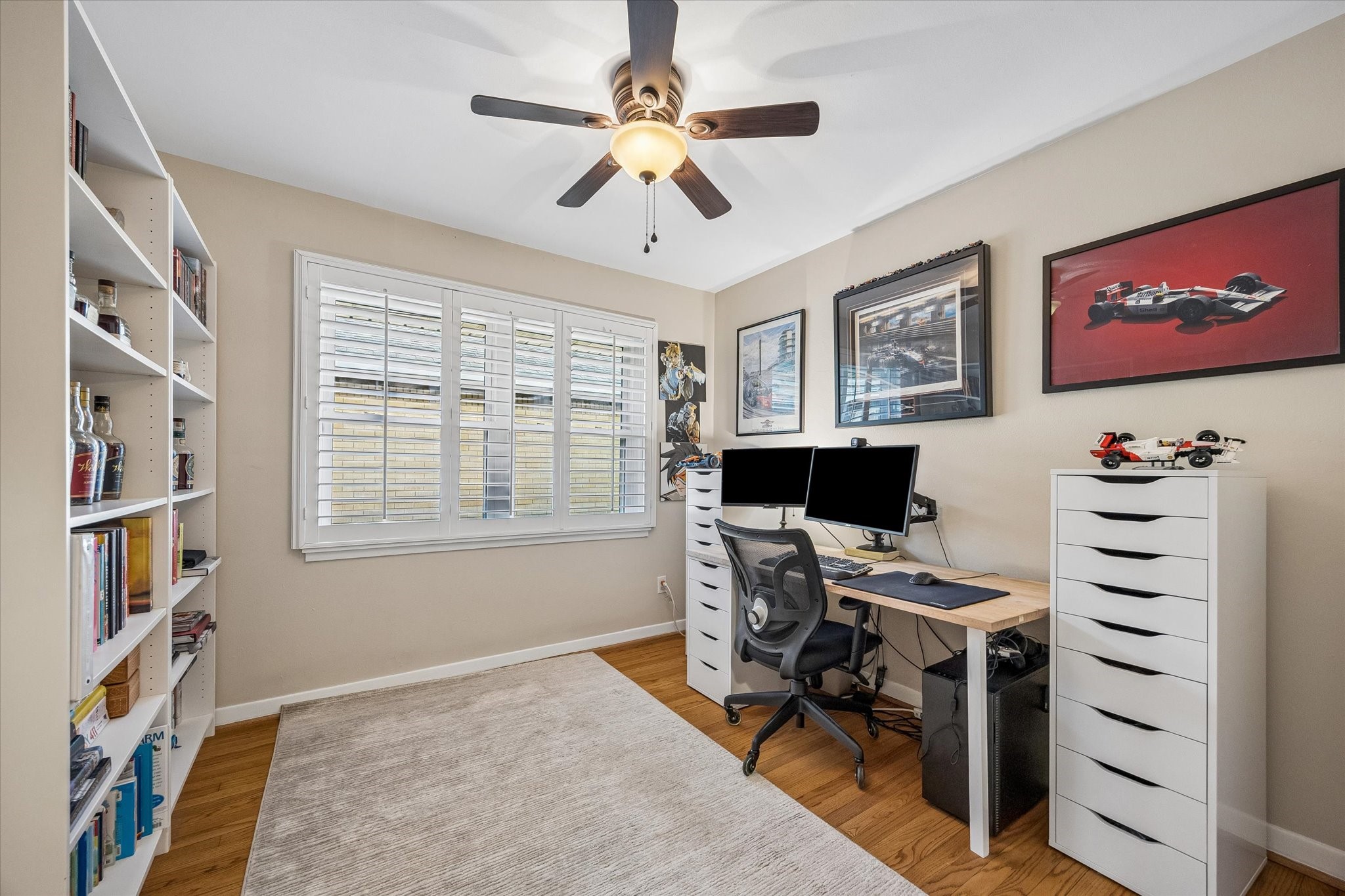 Flexible bedroom can also serve as a dedicated home office or hobby room. A shuttered window allows adjustable light and privacy, while wood floors and a ceiling fan carry through the home's interior finishes.