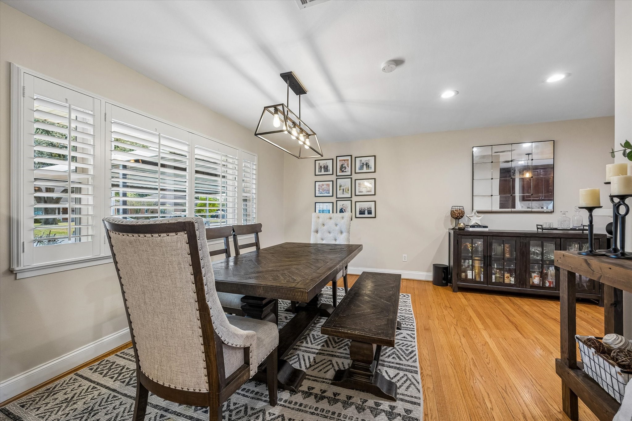 Shuttered windows bring natural light into the front dining area while allowing privacy control. Positioned beside the kitchen, this defined gathering space works well for everyday meals and larger occasions.
