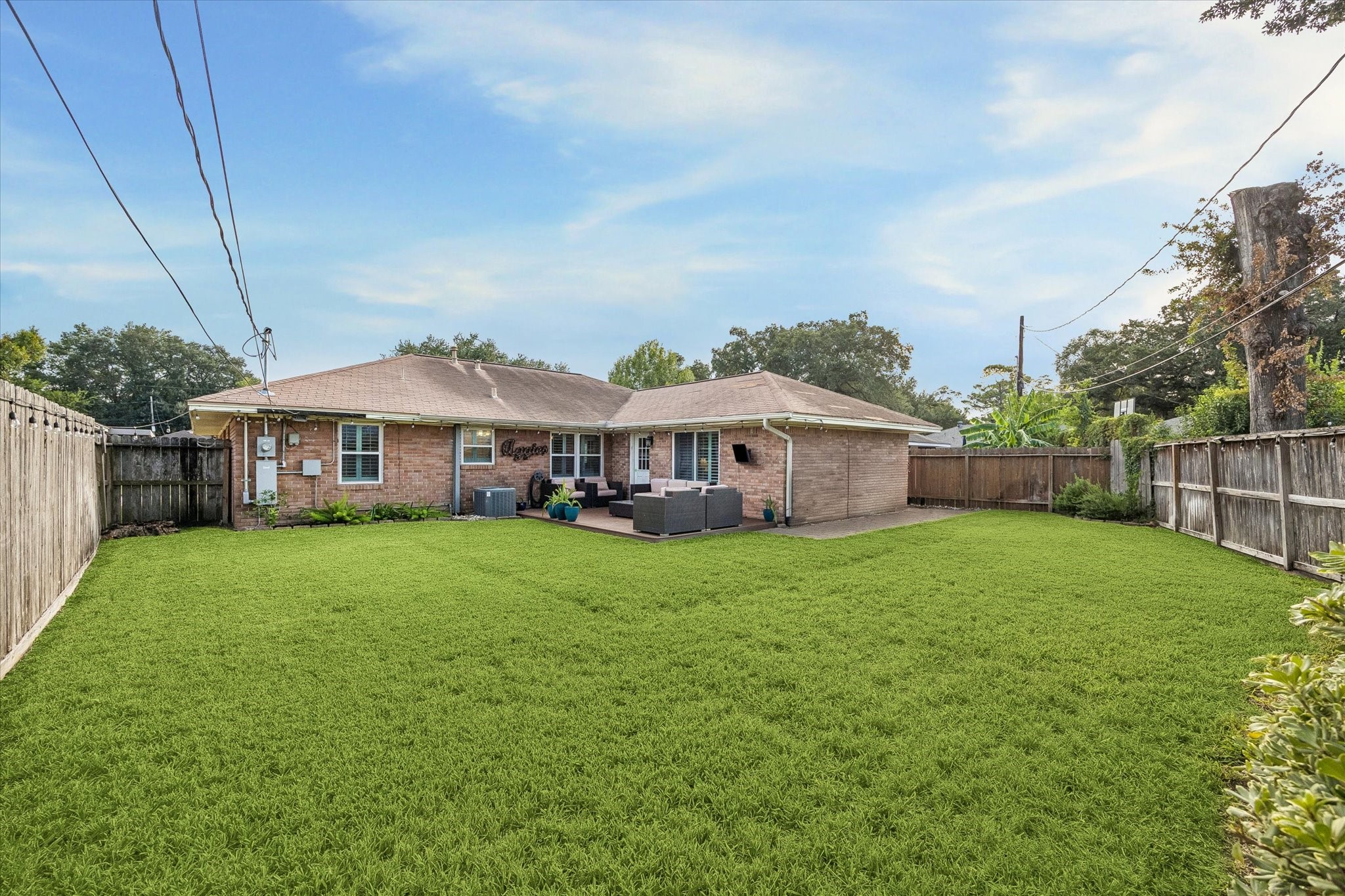 Wide rear view shows how the home, deck and lawn work together across the backyard. Open yard space adds flexibility for outdoor activities, while an irrigation system supports care of the front and back landscaping.