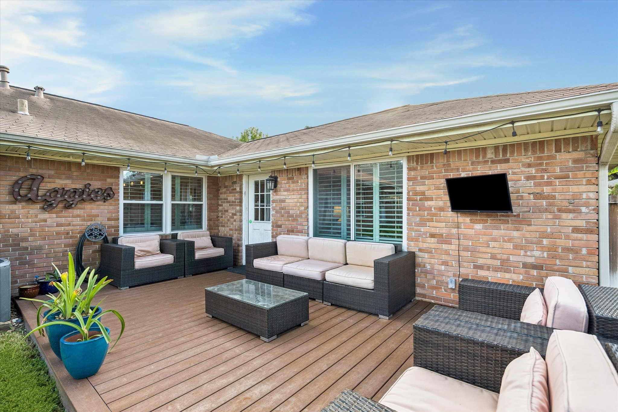 Large rear deck extends the home's living space outdoors with room for dining, gathering and relaxing. Its placement alongside the house creates an easy transition from the interior while keeping the backyard lawn available for other activities.