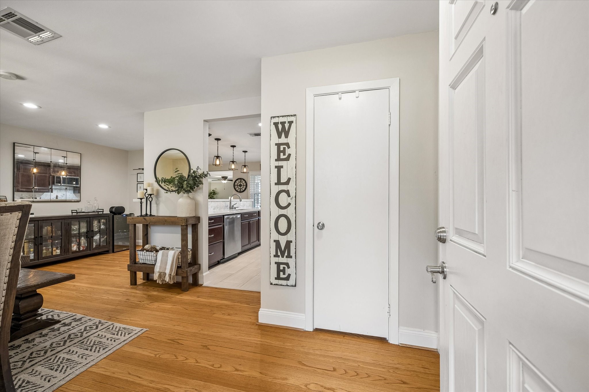 Wood floors carry through the entry into the front dining area, introducing the home's connected layout. Open circulation makes it easy to welcome guests and move between the kitchen, dining and living spaces.