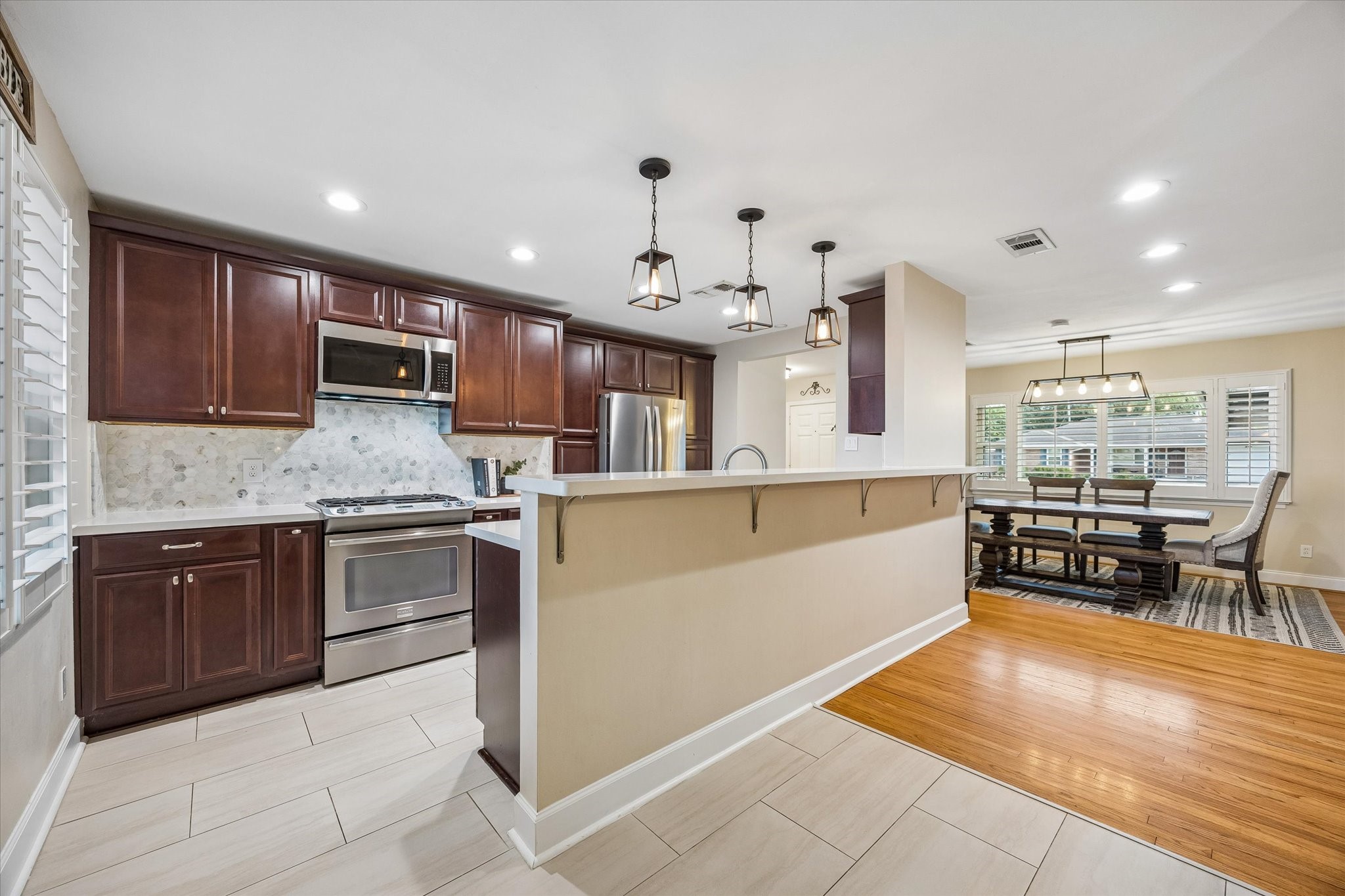 Open connections between the kitchen, dining area and breakfast room help keep everyone together during meal preparation and gatherings. A breakfast bar adds space for casual meals, serving and conversation.