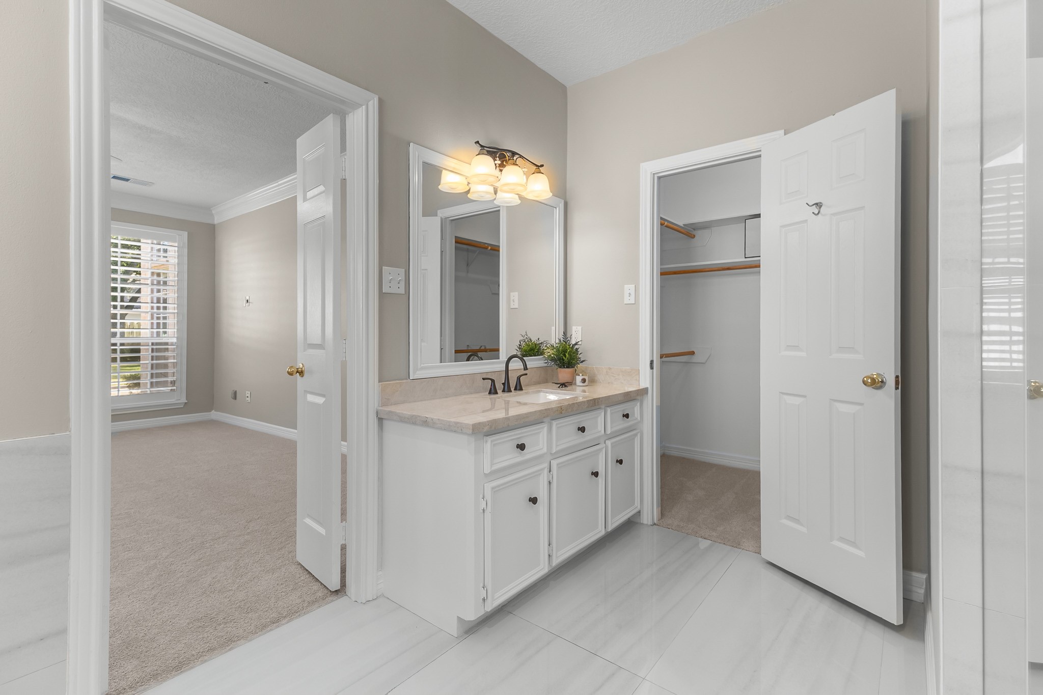 A bright vanity area and adjoining closet access create a practical, well-connected primary suite layout.