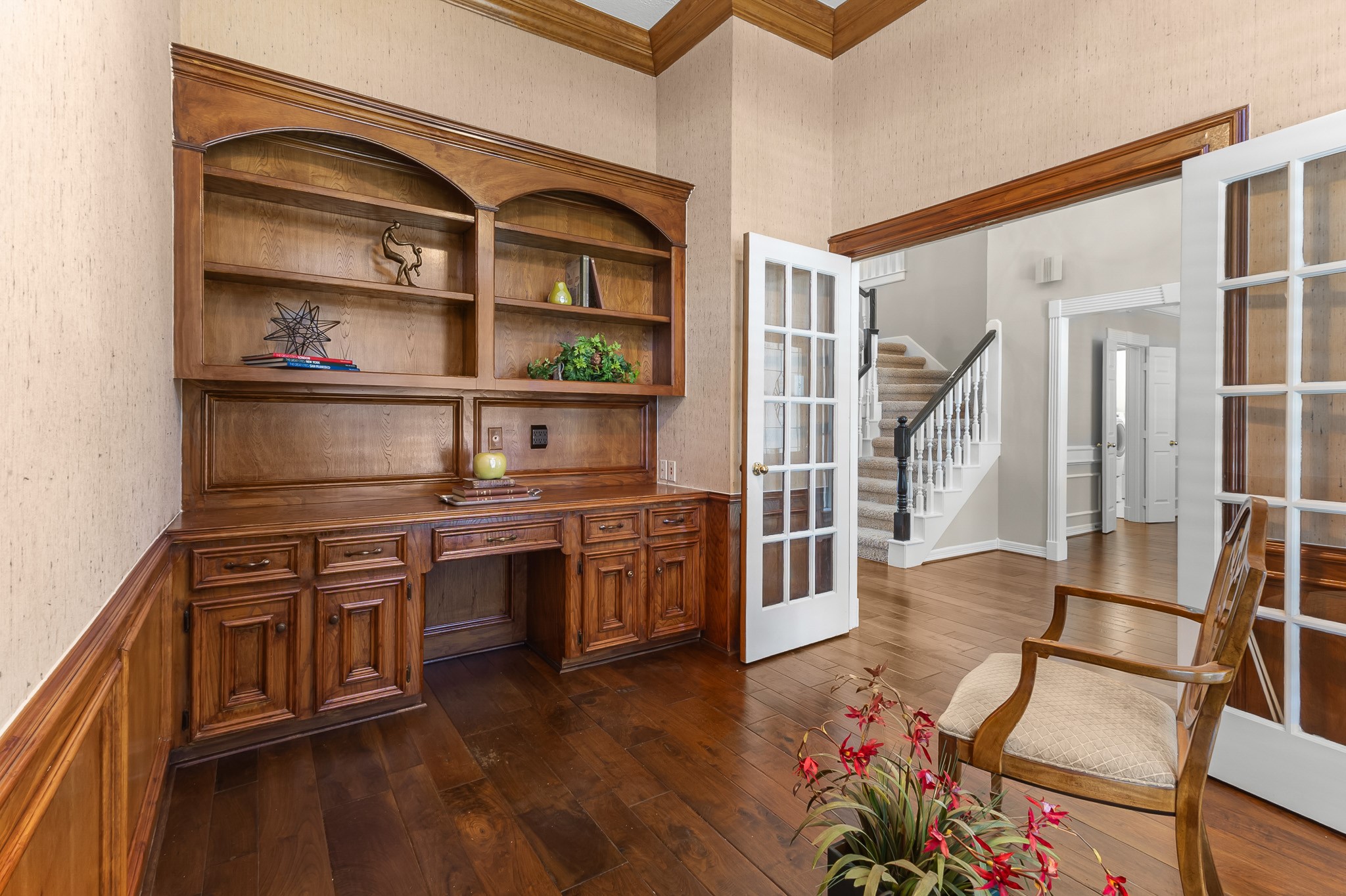 Custom-style wood cabinetry and an integrated desk create a distinguished workspace with timeless character.