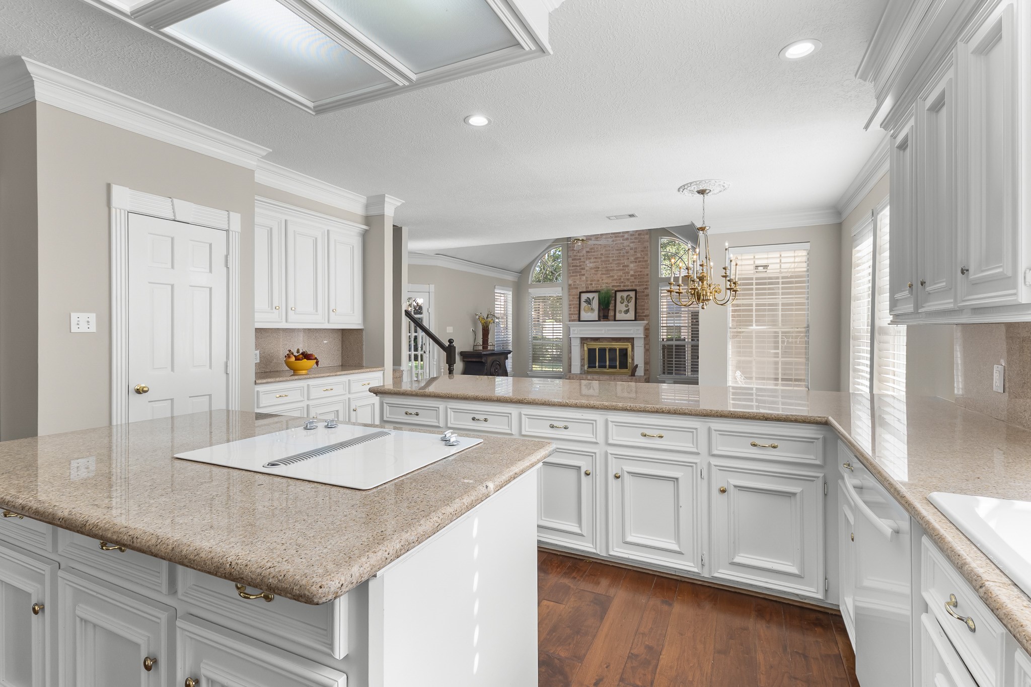 A spacious island anchors the kitchen, surrounded by extensive cabinetry and connected to the adjoining living areas.
