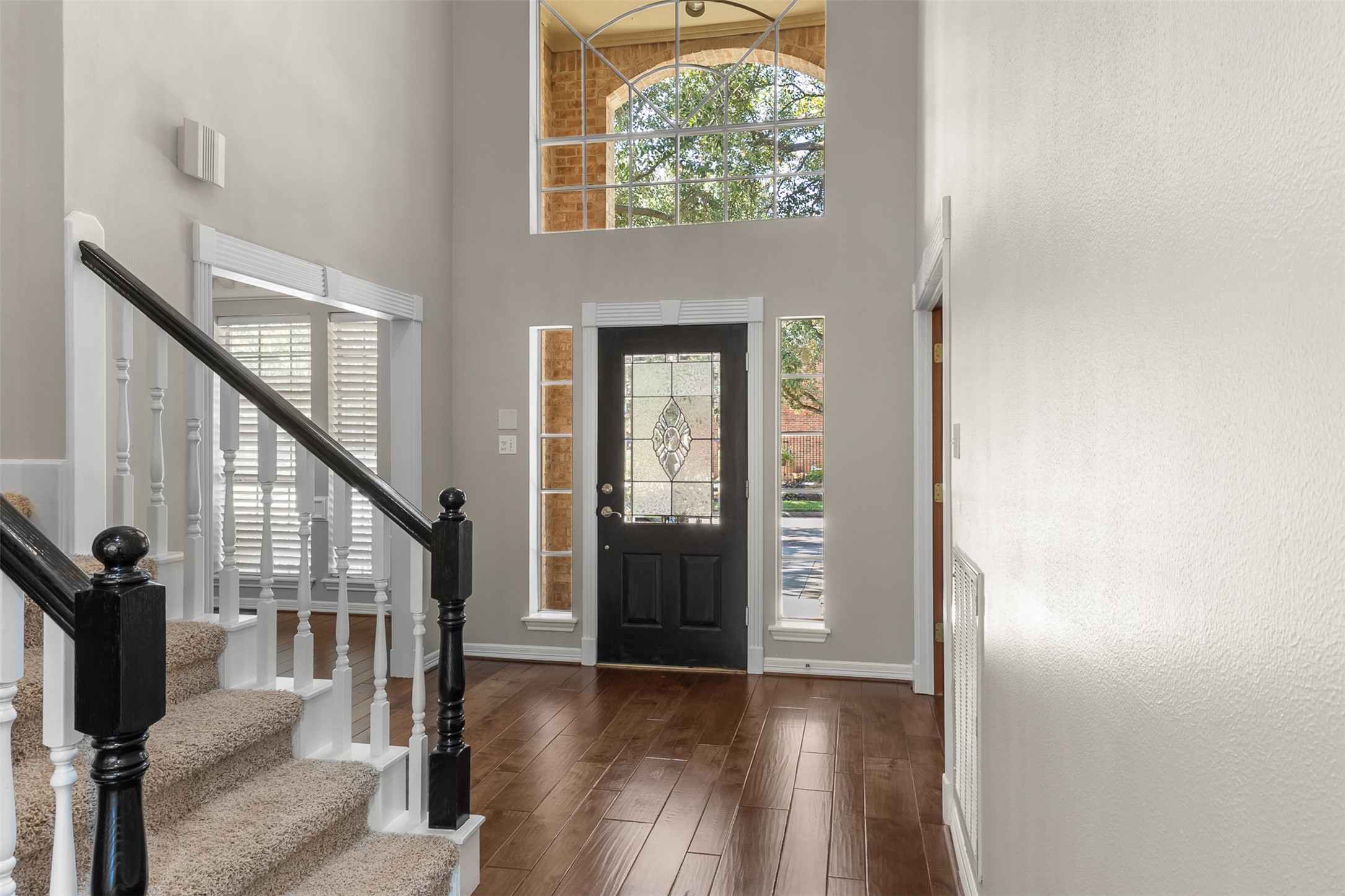 The stately grand entry immediately captures attention, welcoming guests with soaring high ceilings and an abundance of brilliant natural light that creates an airy, open atmosphere.
