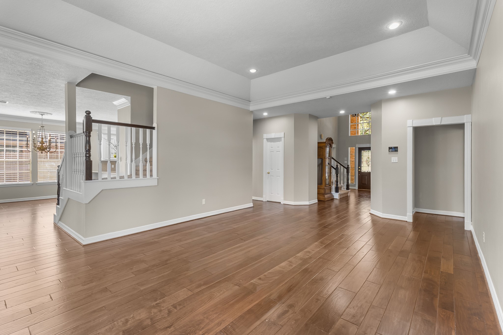An expansive view highlights the rooms flexible layout, elegant ceiling details and seamless connection to the adjoining spaces.
