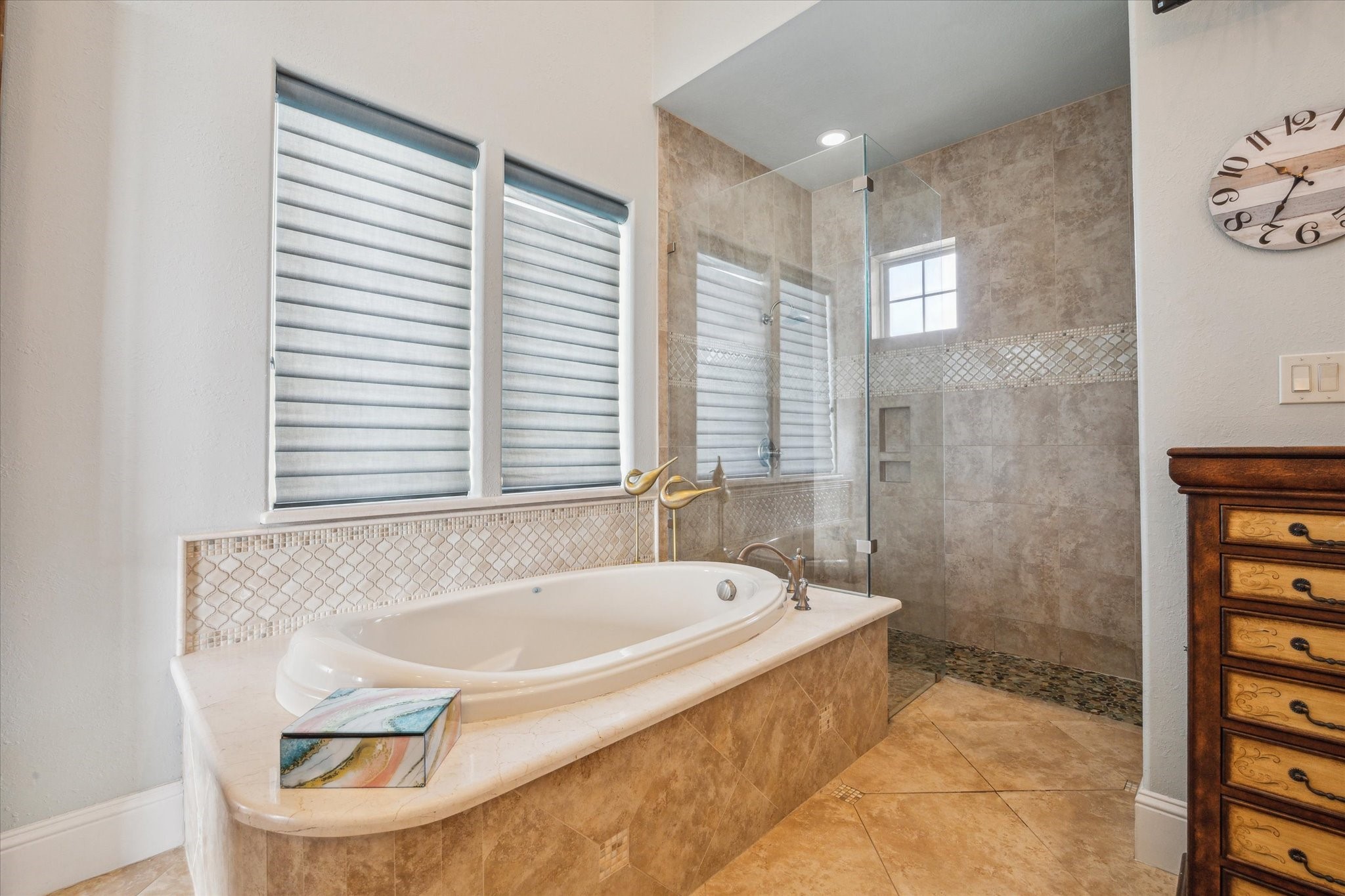 The spa-like ambiance continues in the primary bath with a large soaking tub, and a walk-in frameless glass showerall designed to elevate everyday comfort with timeless elegance. The expansive primary closet offers built-ins and is very spacious