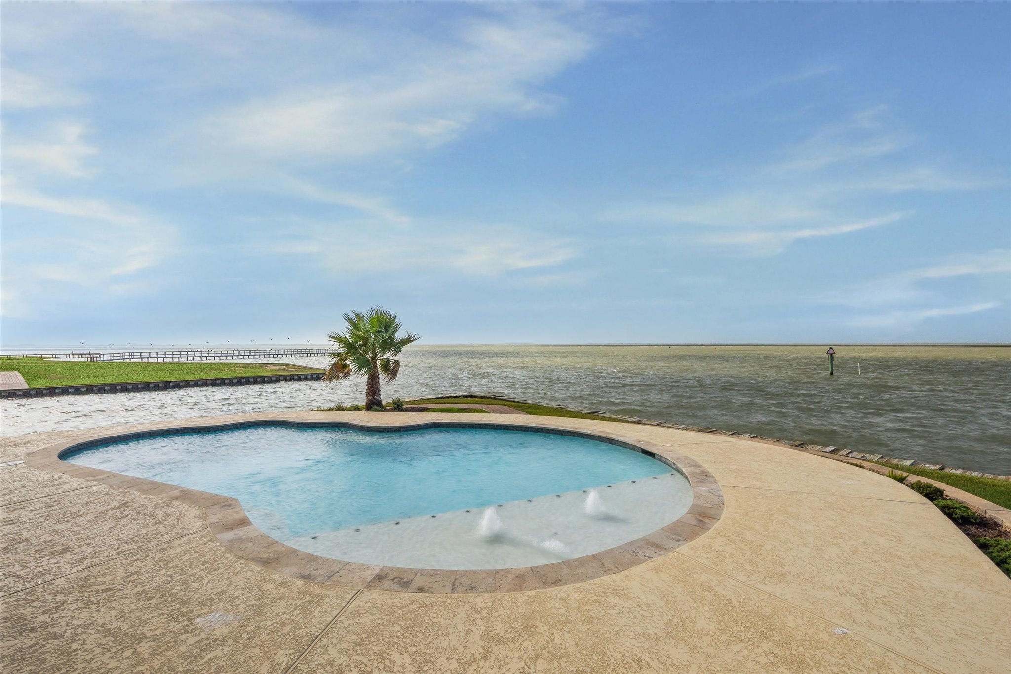 10,200-gallon capacity swimming pool overlooking West Galveston
Bay, including tanning ledge and side wall seating benches throughout,
with all pool equipment raised 5 feet on stilt platform. Bayfront views from the left angle of the pool area