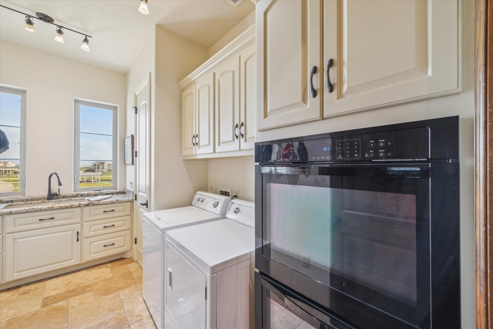 Utility room includes a double sink with garbage disposal and Whirlpool
electric 30-inch double oven; granite countertop