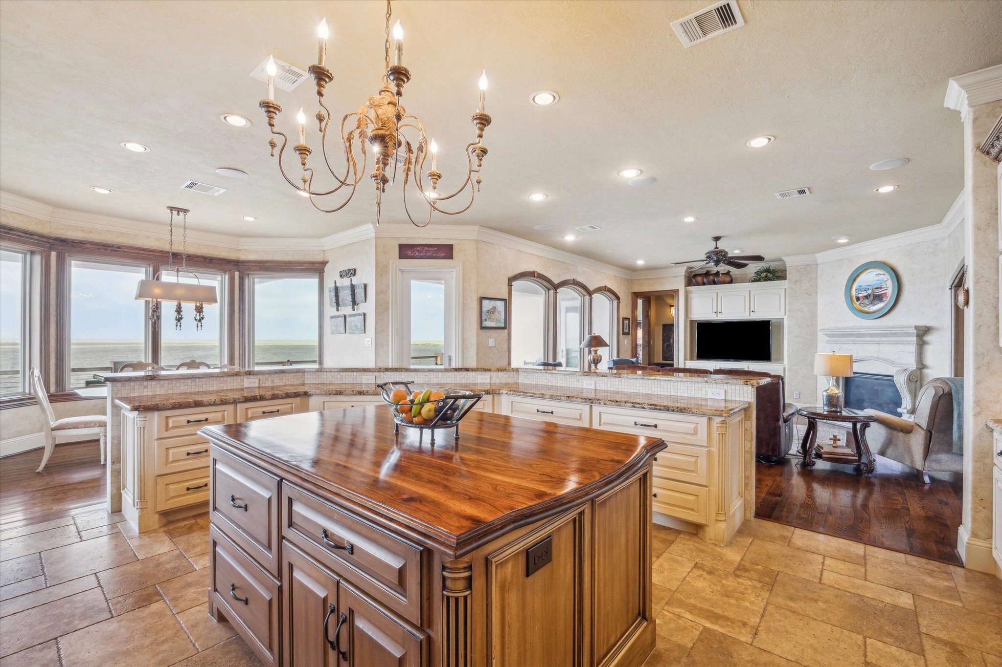From this impeccably designed kitchenfeaturing custom cabinetry, granite countertops, and designer lightingenjoy an effortless flow into the refined living and dining spaces, all framed by a wall of windows showcasing unobstructed, panoramic views of West Galveston Bay