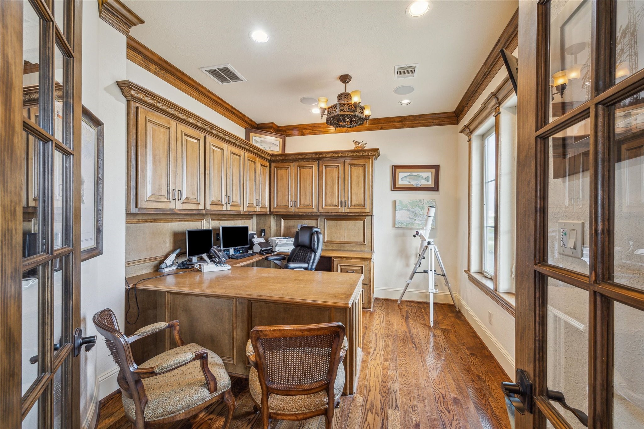 A dedicated home office or study features double entry doors, rich stained cabinetry, a built-in desk, and ample storageoffering both functionality and sophistication in a private workspace A dedicated home office or study features double entry doors, rich stained cabinetry, a built-in desk, and ample storageoffering both functionality and sophistication in a private workspace
