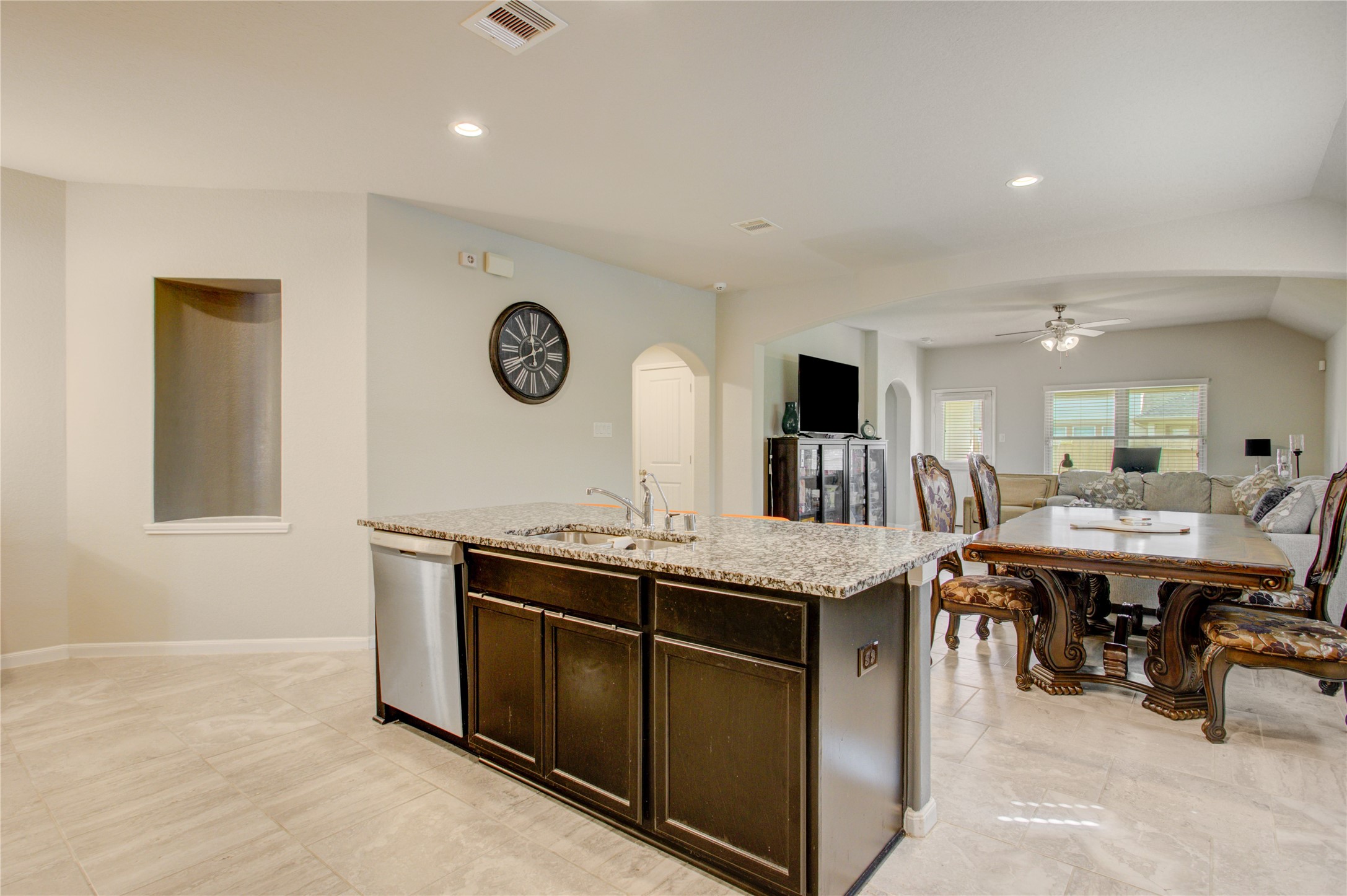Gather around the spacious granite island featuring an undermount sink, dishwasher, and generous prep space.