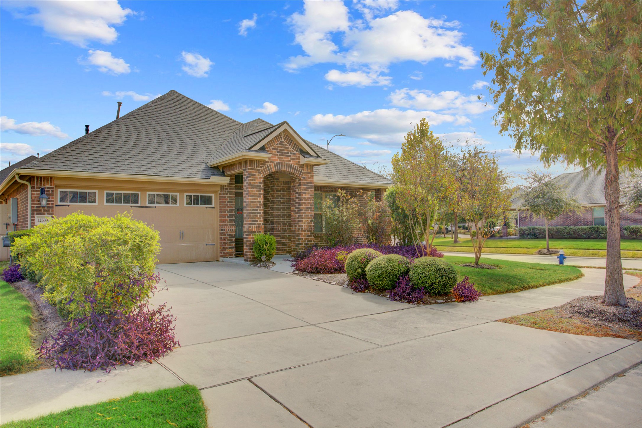 Stunning curb appeal with mature landscaping, a spacious driveway, and an attached two-car garage. REMEMBER FRONT LAWNCARE IS INCLUDED!