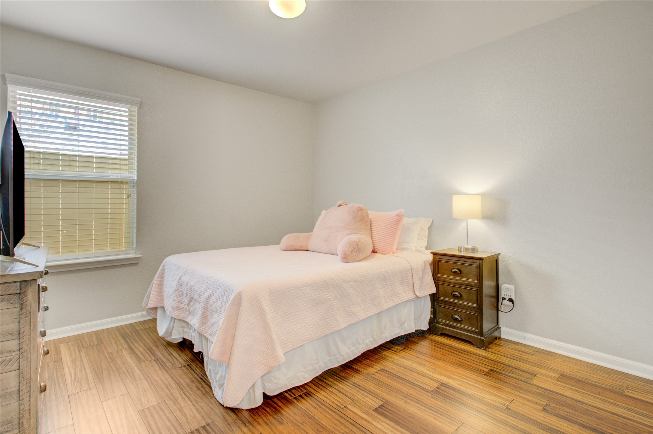 Bright and inviting secondary bedroom with wood flooring and natural light!