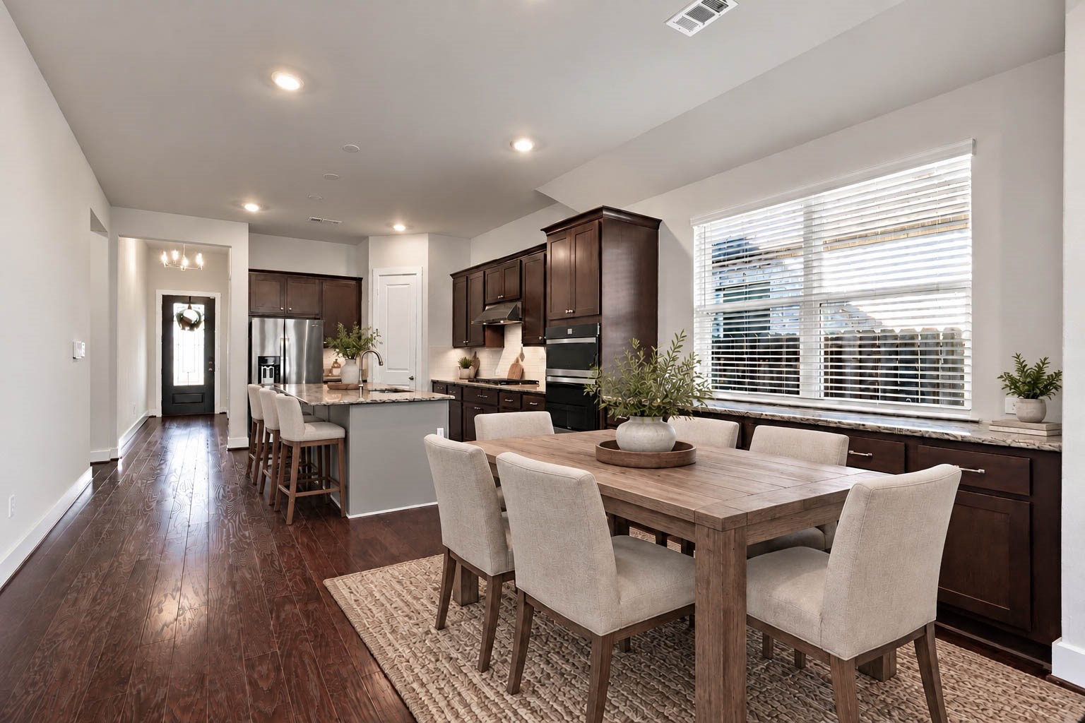 The spacious casual dining area flows seamlessly into the main family room, featuring an expansive built-in buffet with matching dark cabinetry and granite countertops that provide incredible storage and serving space for gatherings. *Virtually Staged