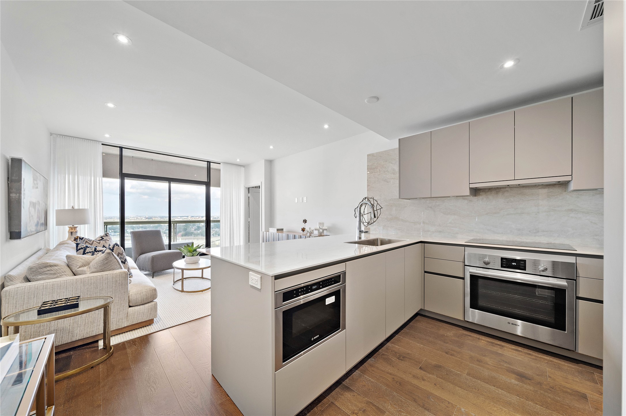 High-end kitchen open to living area and bonus beautiful views. Color scheme in photo is from a similar unit.
