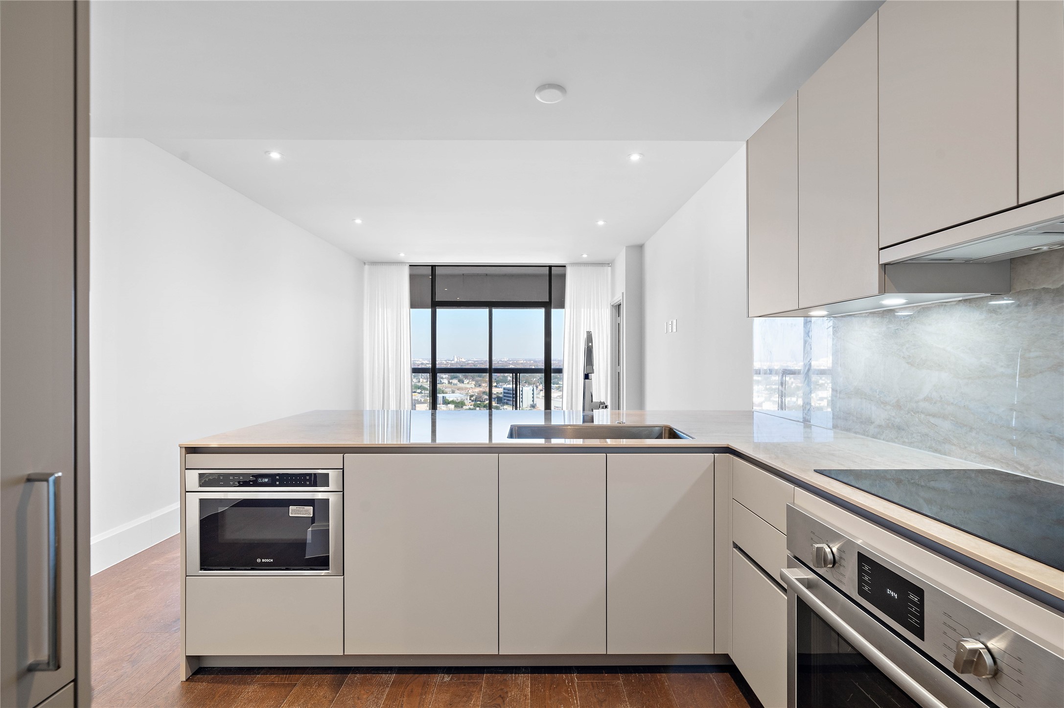Premium Bosch appliances including convection oven, induction cooktop drawer microwave, panelized dishwasher and refrigerator-freezer.