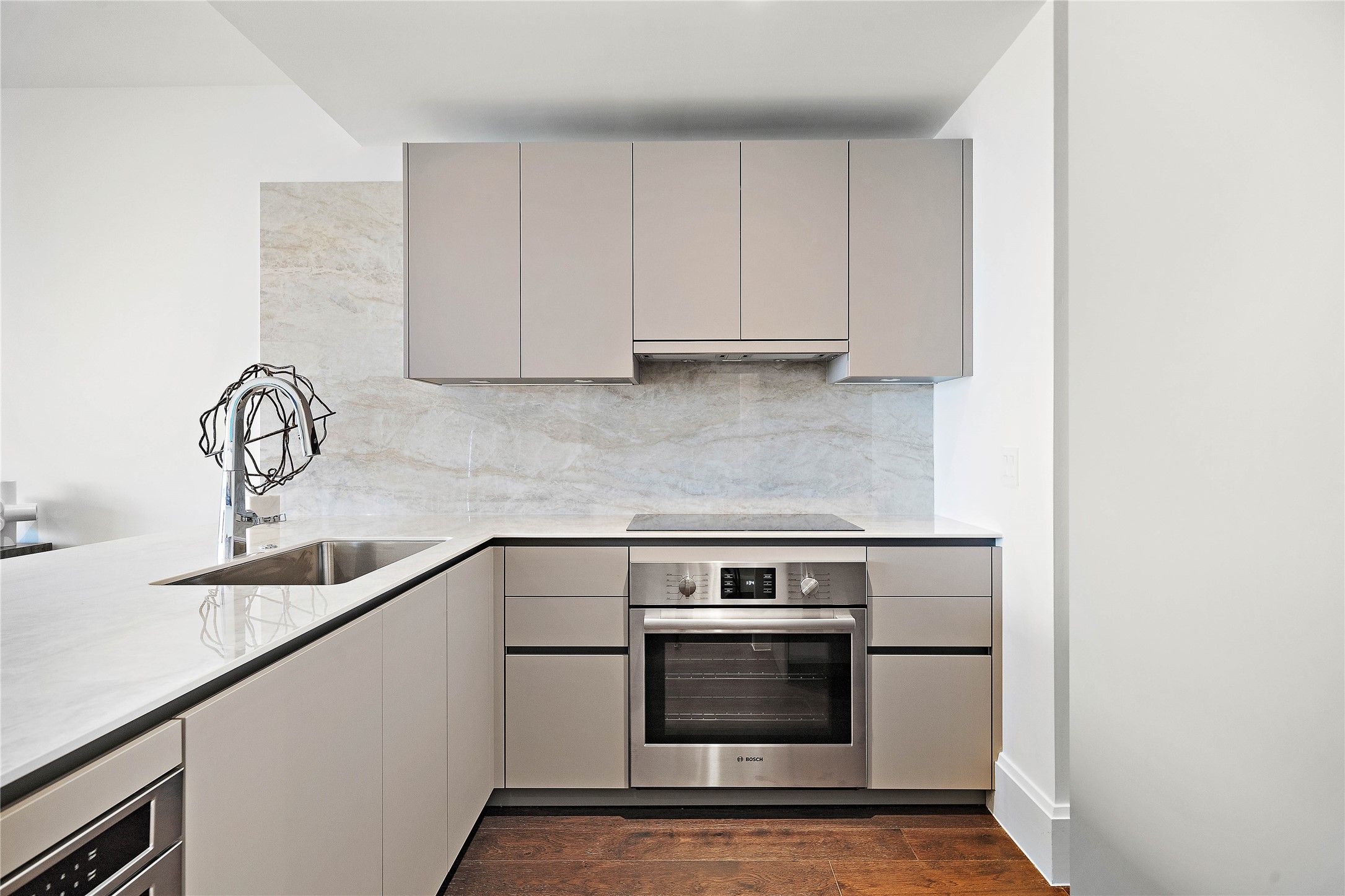Porcelain countertops and slab backsplash complement the rich cabinetry push-touch cabinetry.