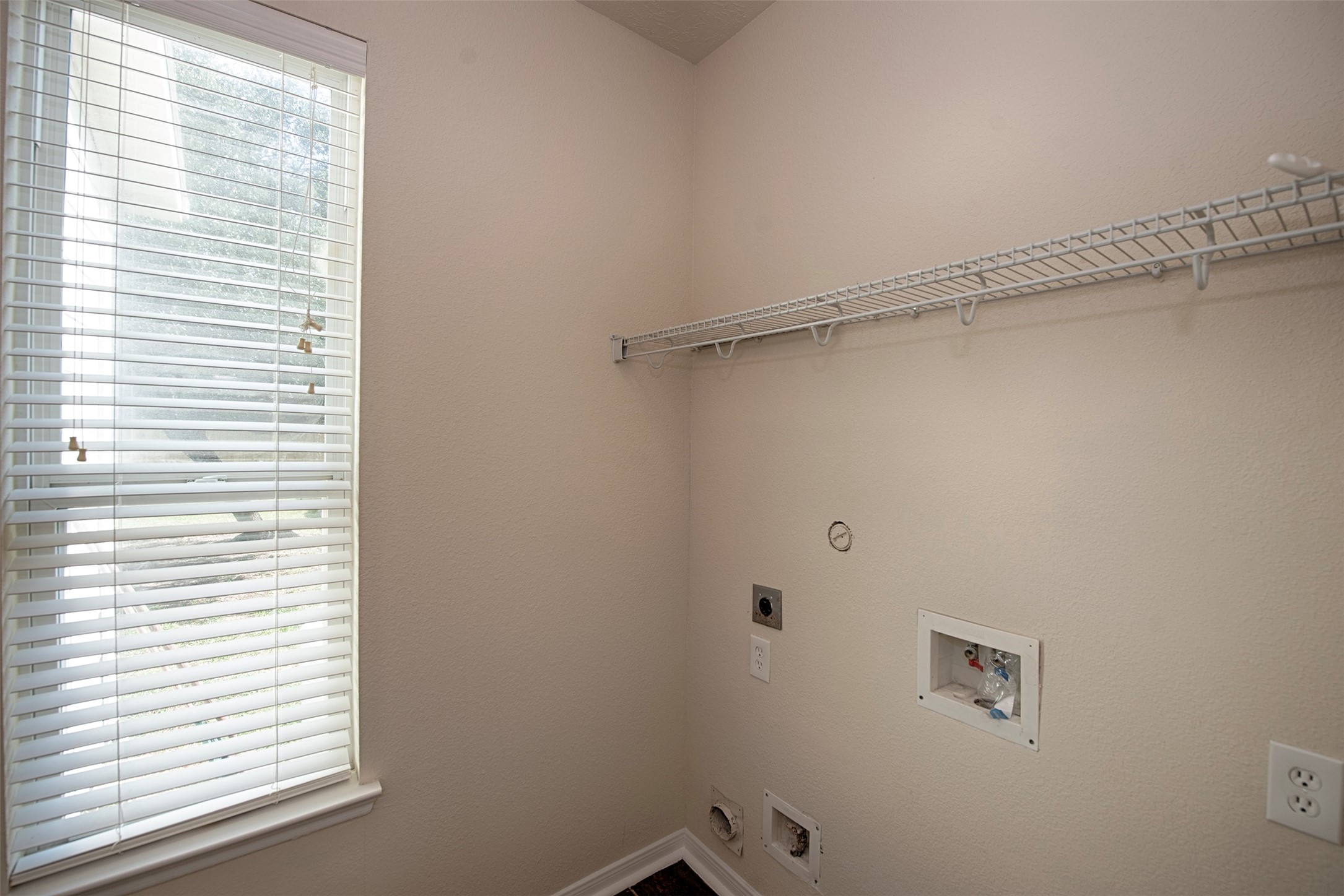 Downstairs is the utility room with space for large front loading washer and dryer. Great shelving for your laundry essentials and area to hang your garments after taking them out of the dryer.