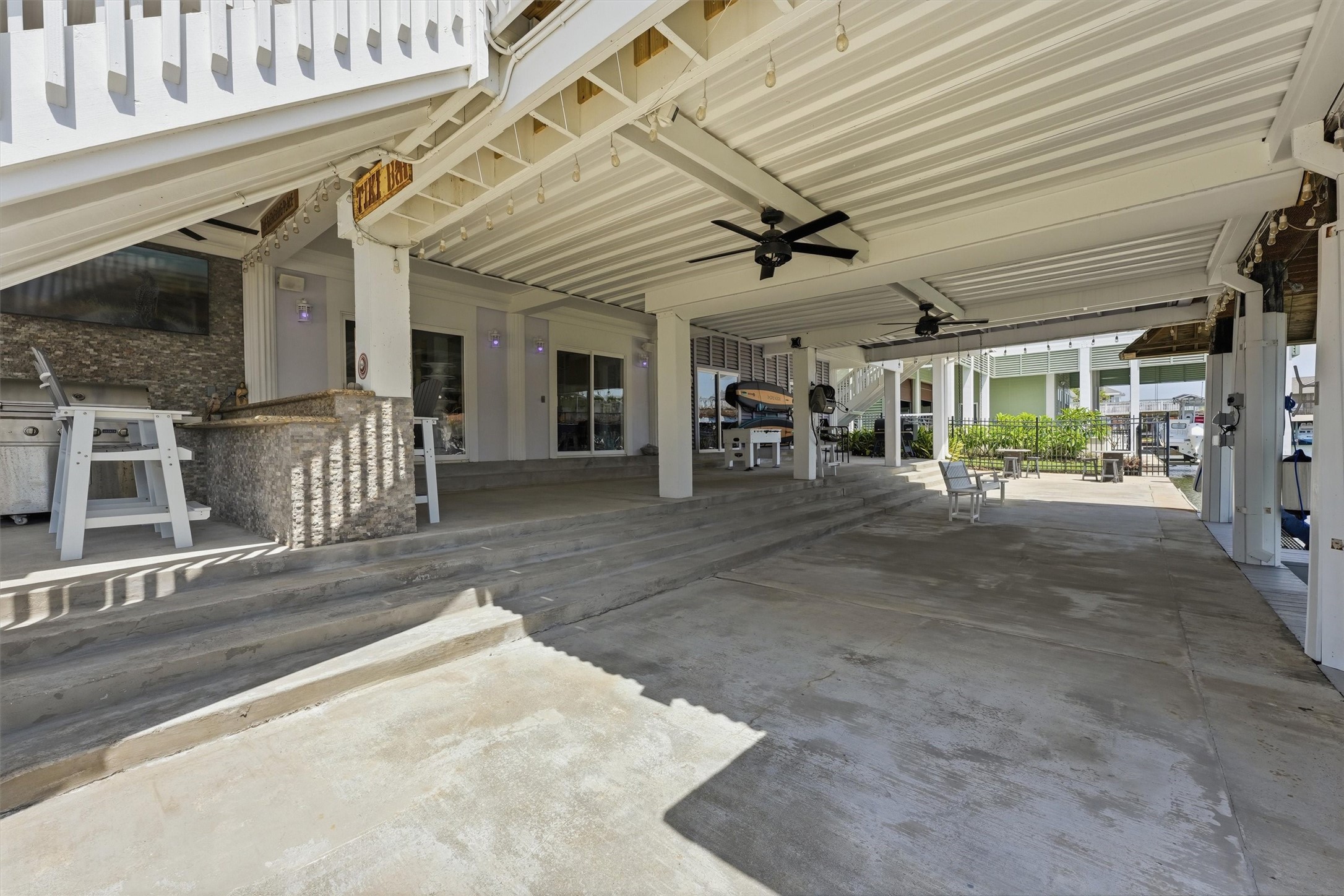 Large covered outdoor living area extends the home's entertaining space with plenty of room for gathering, dining, and relaxing near the pool and waterfront.