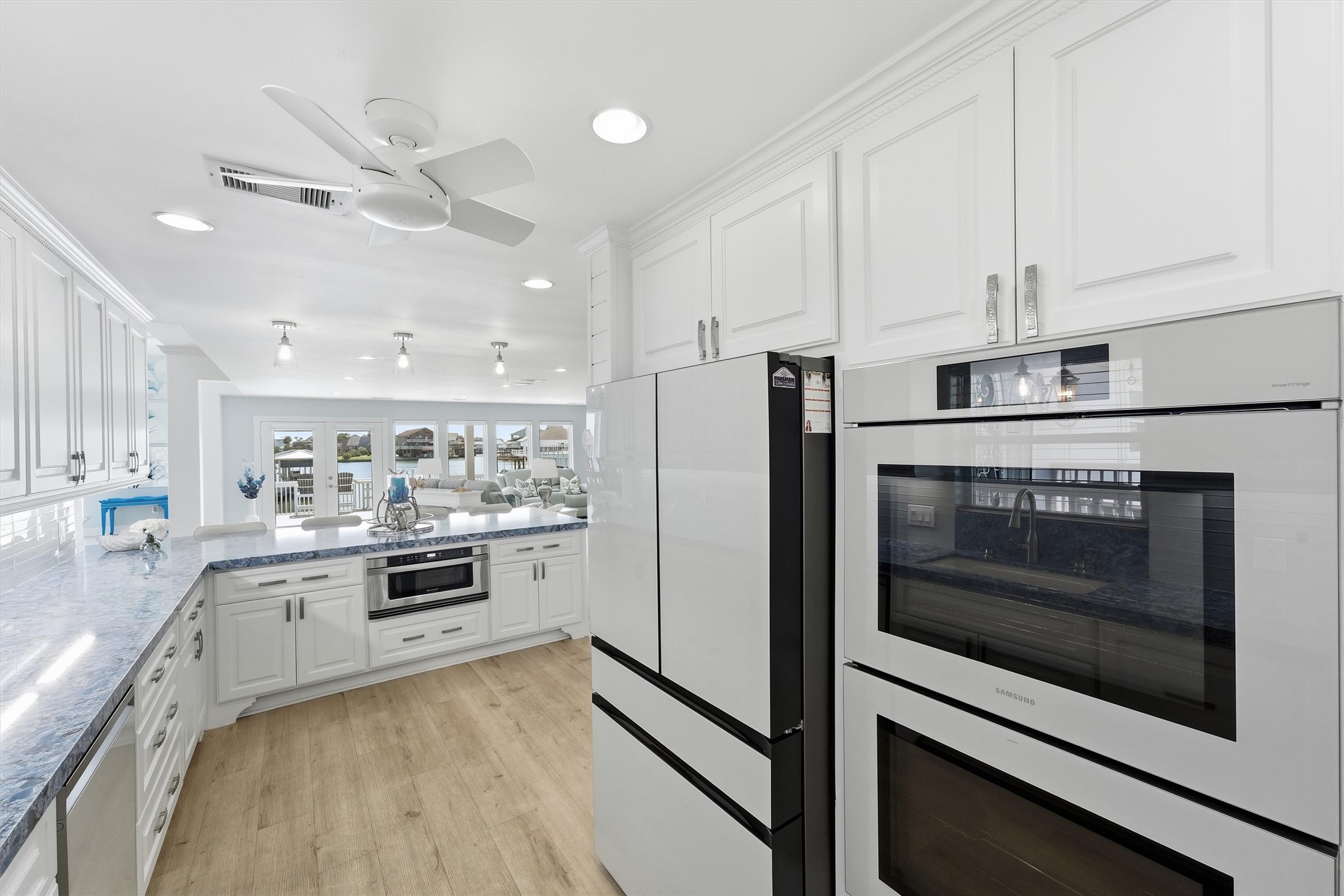 Well-appointed kitchen with Samsung Bespoke appliances, double ovens, extensive cabinetry, and an open connection to the waterfront living areas.