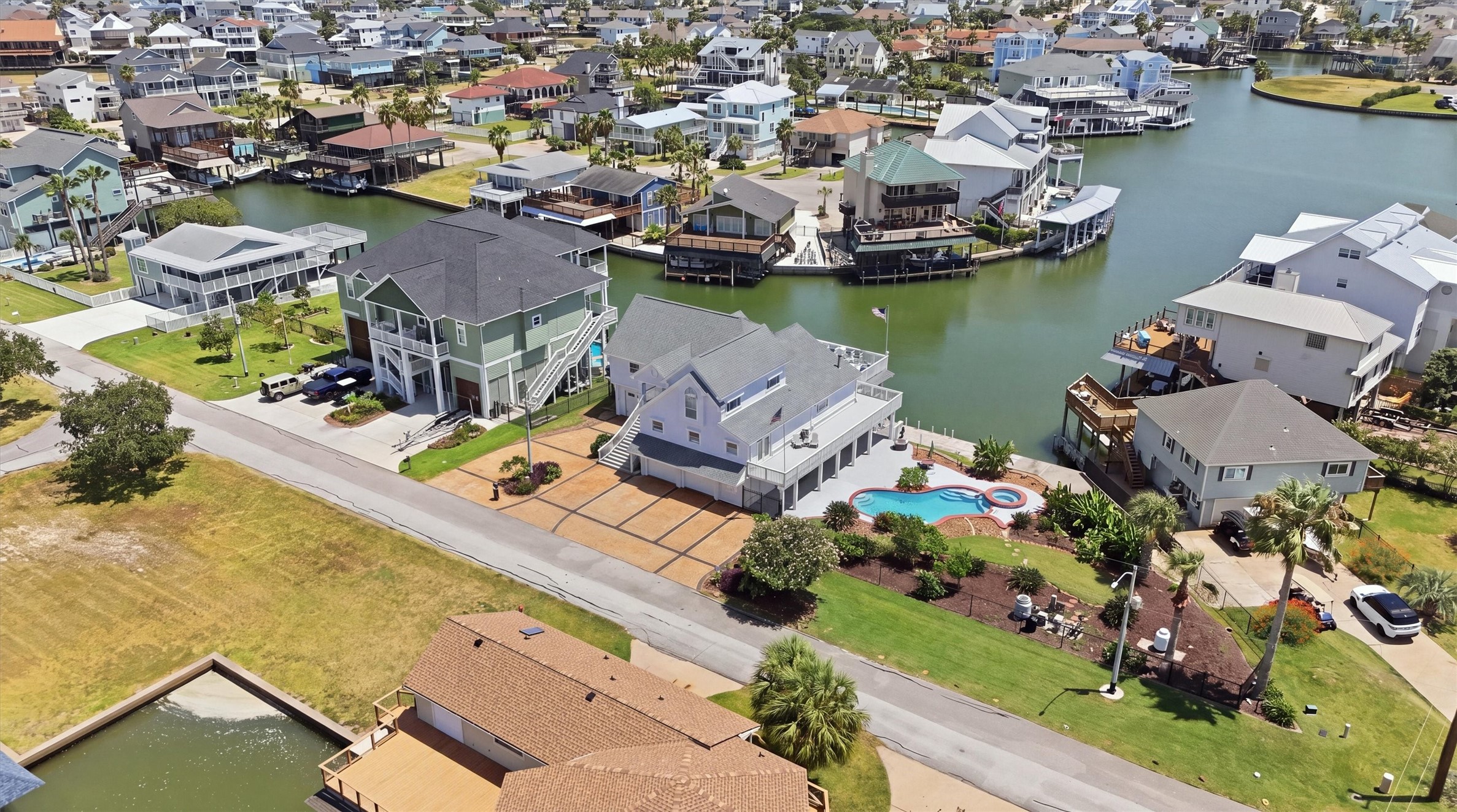 The expansive stamped driveway offers plenty of parking for family and guests, making it easy to entertain a crowd while still enjoying the homes pool, spa, outdoor spaces, and waterfront setting.