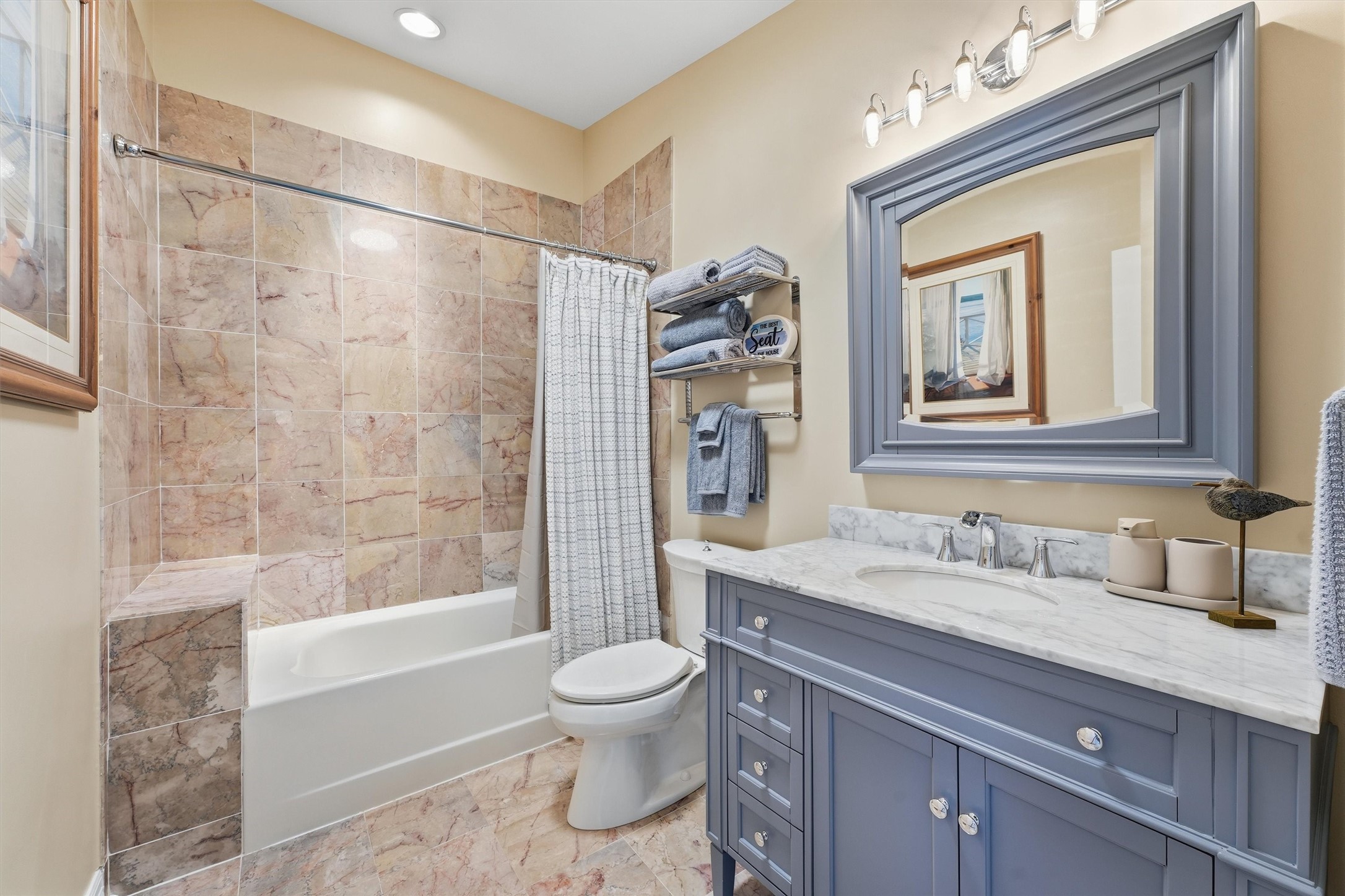 Full secondary bathroom features a spacious vanity, tub/shower combination, and tile surround.