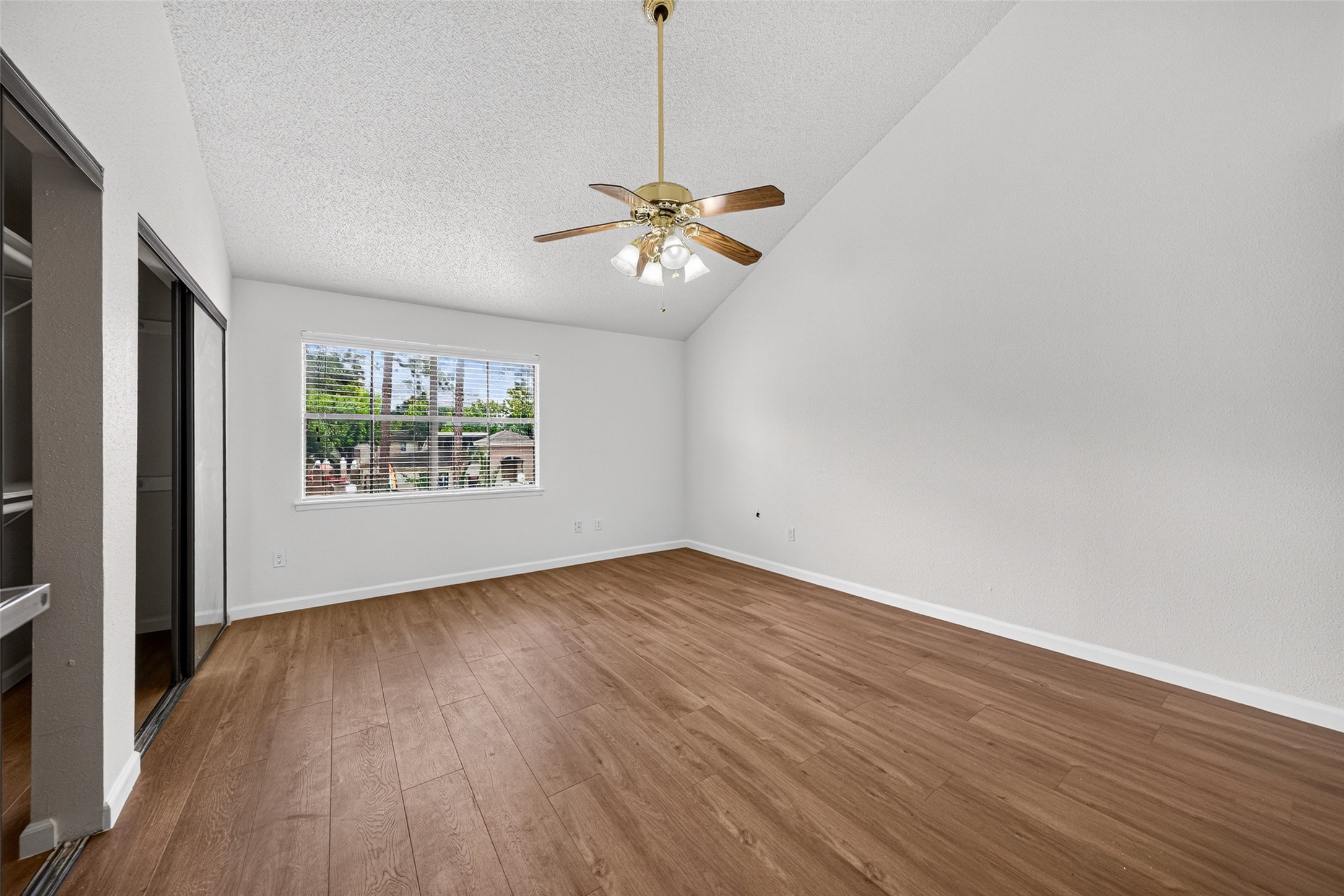 Spacious primary bedroom with vaulted ceiling