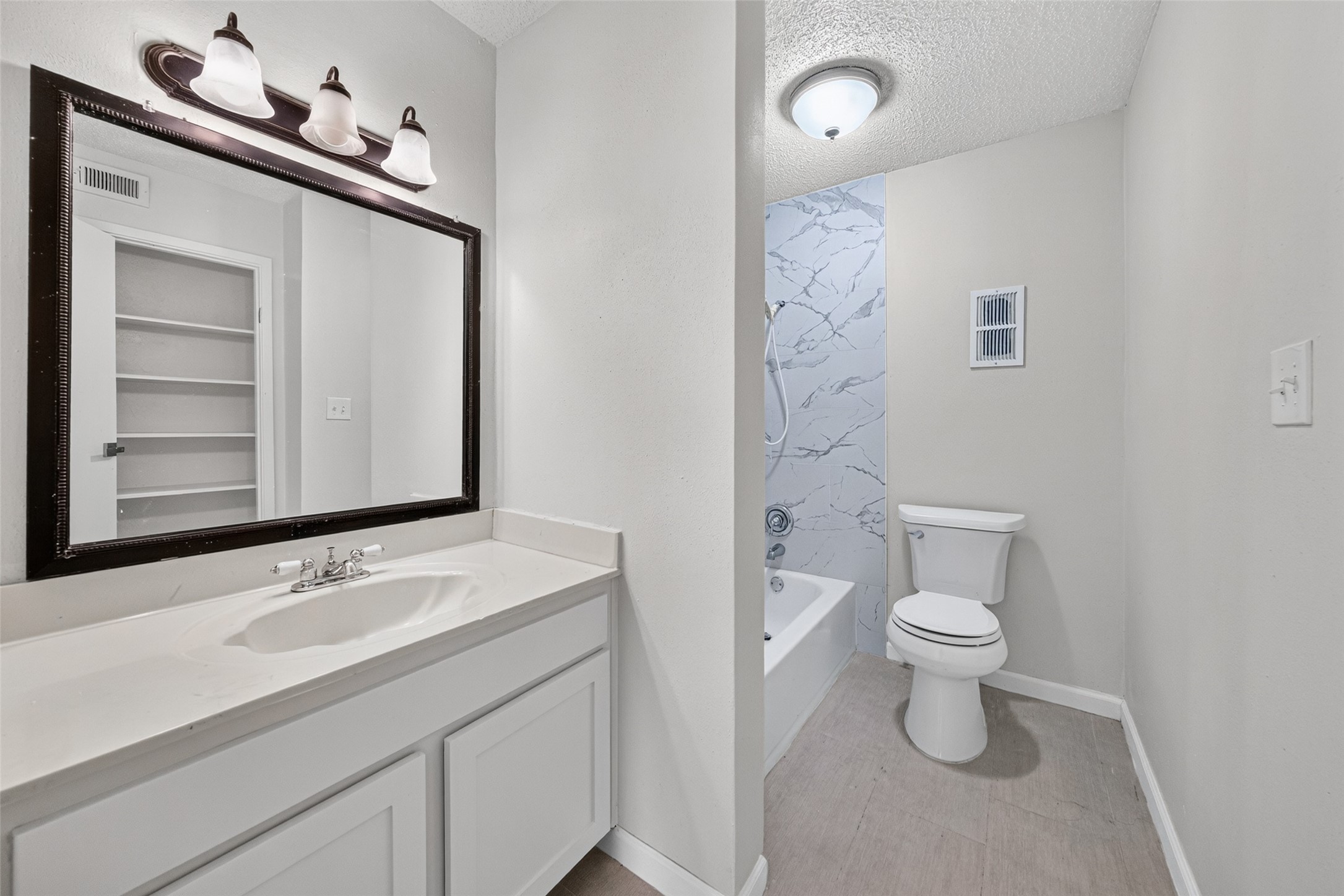 Primary bathroom with vanity and tub/shower combination