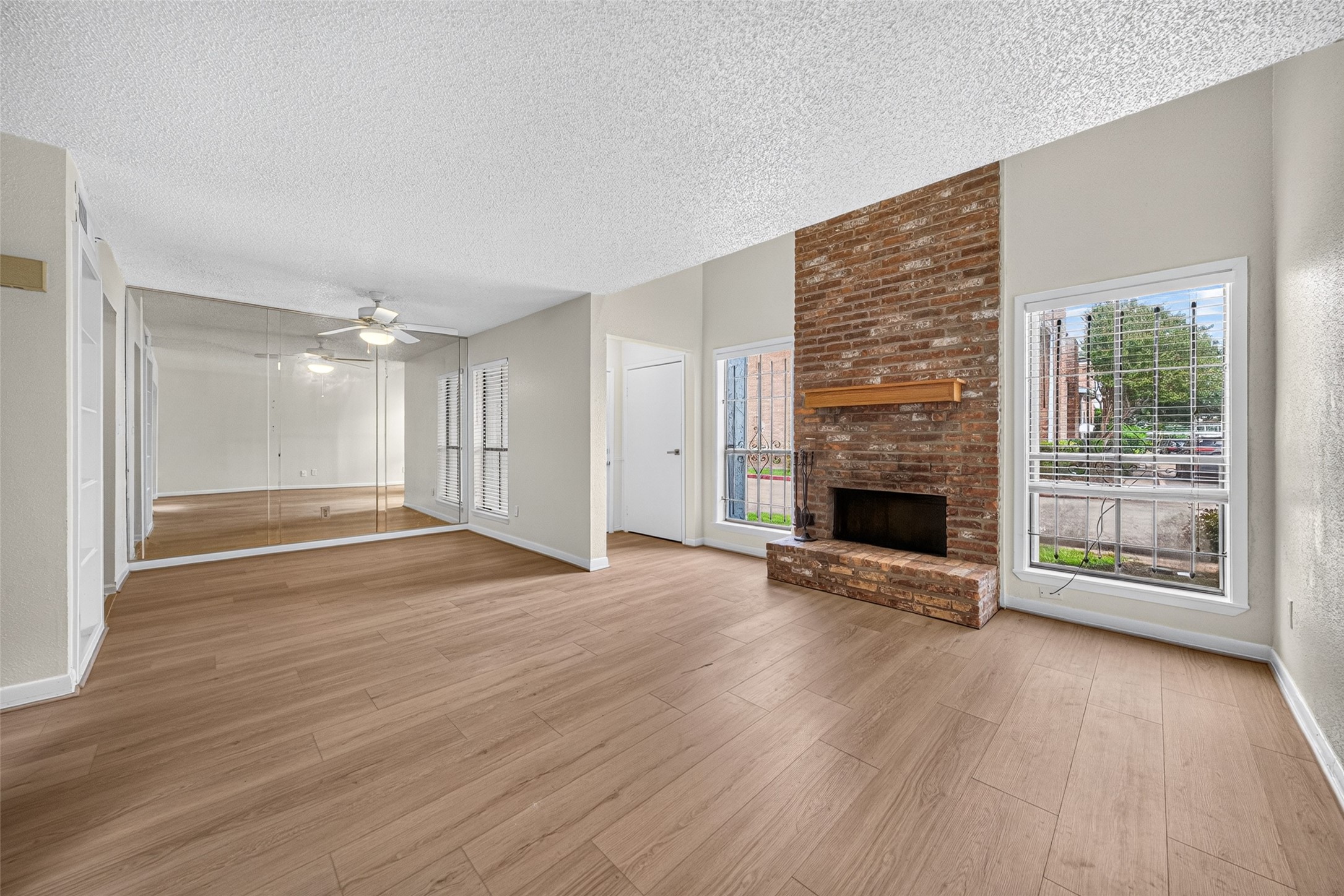 Spacious living room with brick fireplace and natural light
