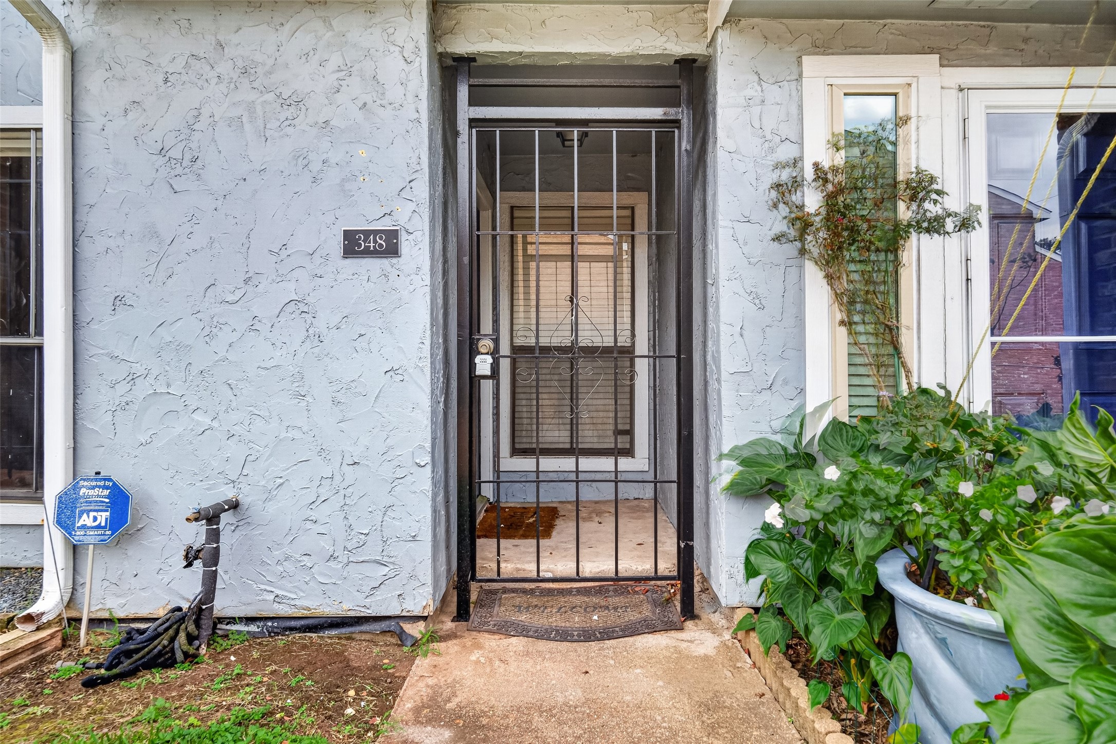 Welcoming front entrance featuring a wrought-iron security gate and covered entryway.