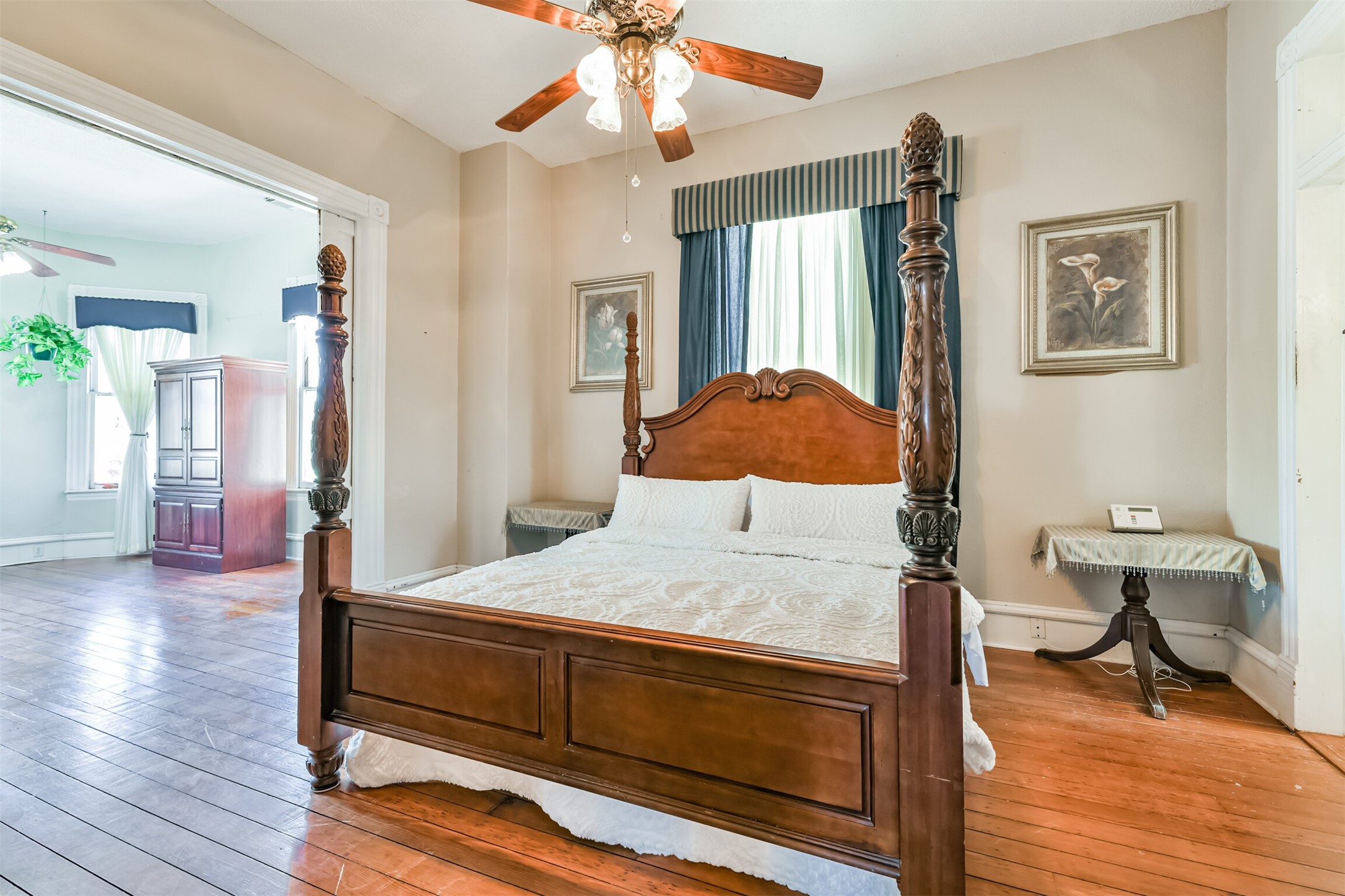 Also located on the second floor, this space is truly a master retreat, boasting a cozy bedroom with an additional parlor area with long leaf pine wood floors, neutral paint, and a lighted ceiling fan.