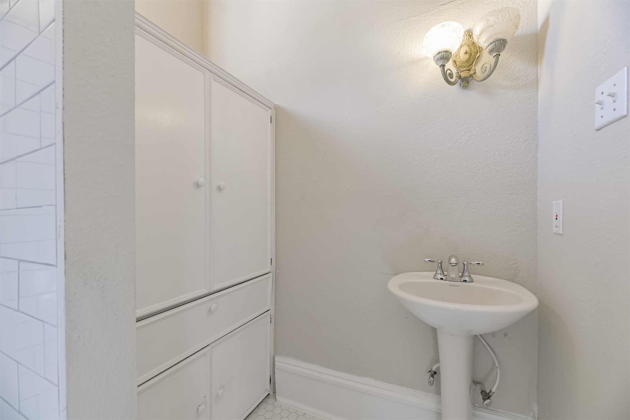 An en suite master bathroom is a pretty extraordinary extravagance in a home from 1895, but this home has one! It features a pedestal sink, hexagonal tile floors, a walk-in shower, and a large built-in cabinet for storage.