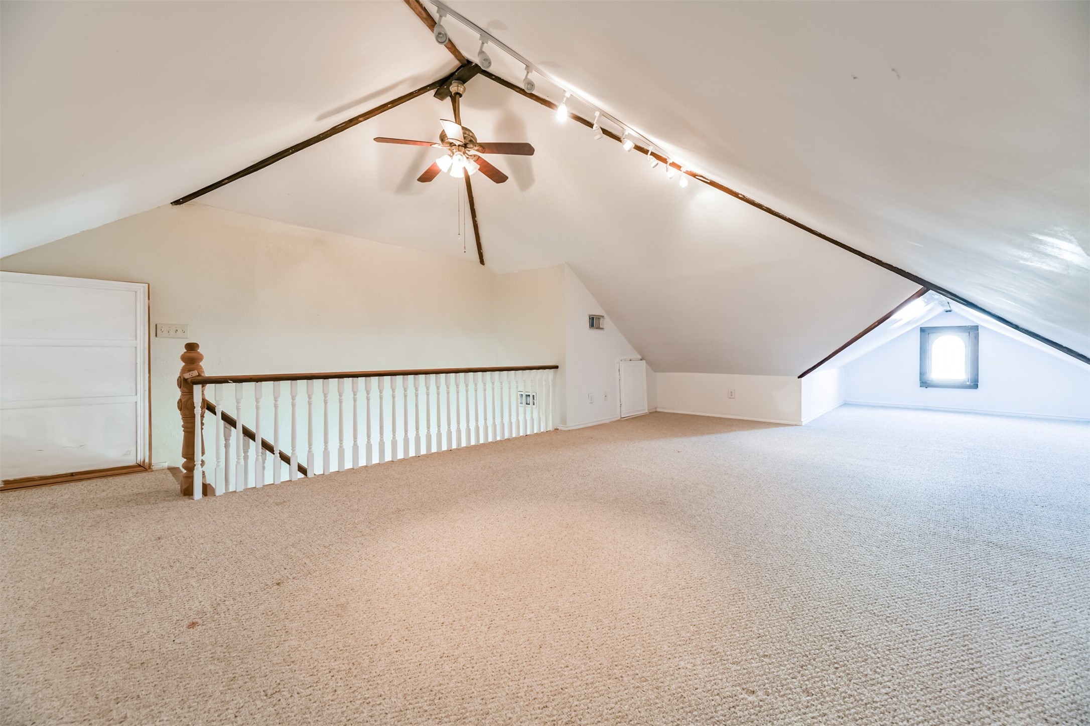 Secluded on the third floor, this air-conditioned multi-use space makes for a great game room or sleepover space! Here, you'll find a peaked ceiling with a lighted ceiling fan, track lighting, Berber carpet, original windows, and built-in storage along the outside walls,